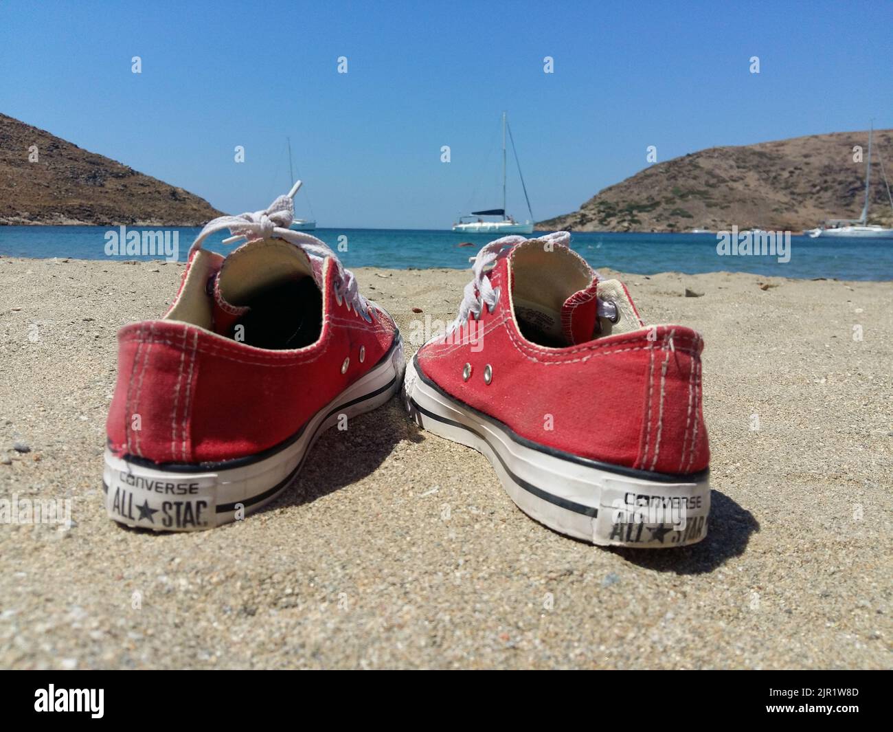 Red All star converse on the sand at Kithnos beach Colona Stock Photo