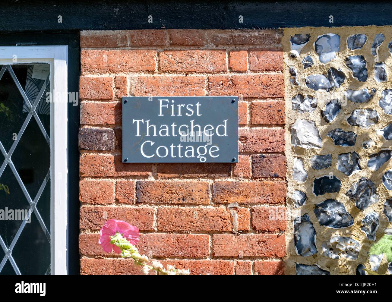 Sign for First Thatched Cottage on brick wall, Flamstead, Hertfordshire Stock Photo
