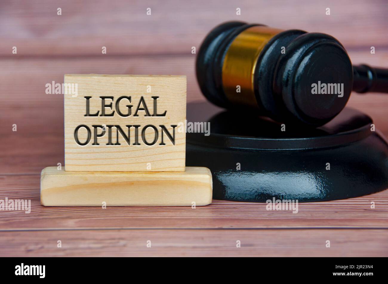 Legal opinion text engraved on wooden block with gavel background. Legal and law concept. Stock Photo