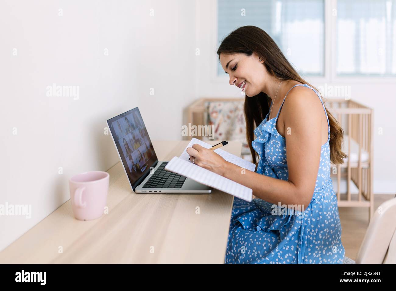 Cheerful young adult student woman having a video call on laptop computer Stock Photo