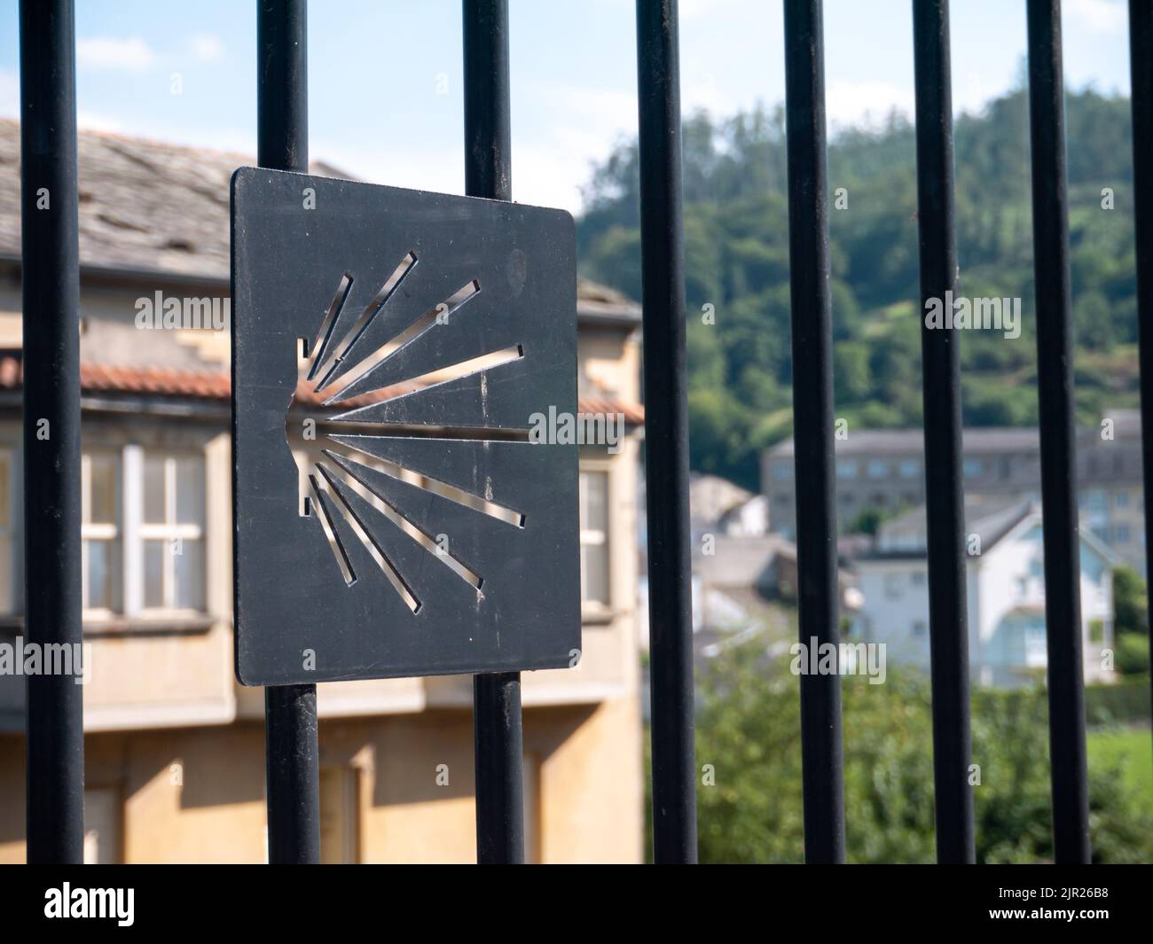 MONDONEDO, SPAIN - AUGUST 14, 2022: Scallop shell Way of St James route sign carved on the metallic fence in the old town Mondonedo,Lugo,Galicia,Spain Stock Photo