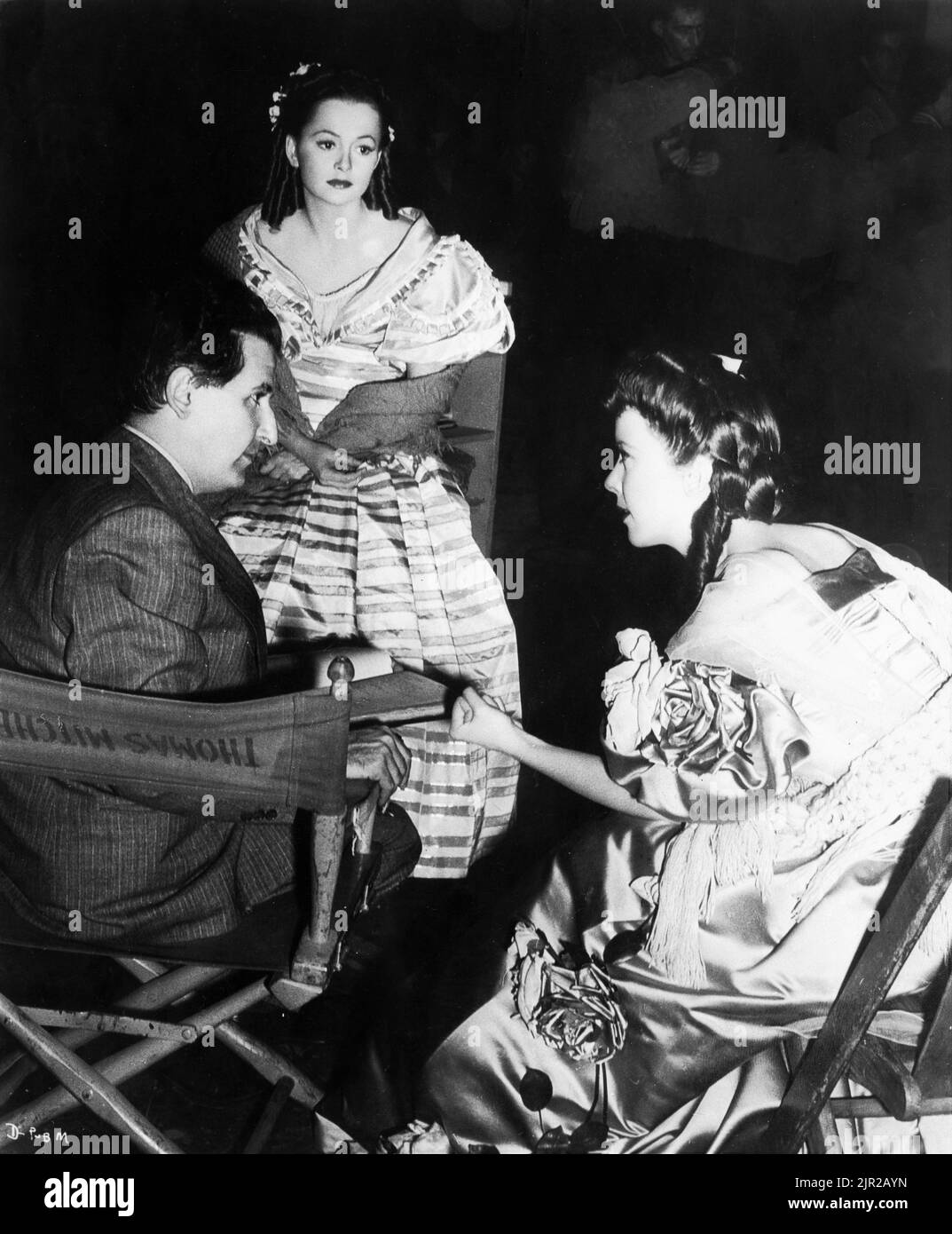 Director CURTIS BERNHARDT OLIVIA de HAVILLAND (in costume as Charlotte Bronte) and IDA LUPINO (in costume as Emily Bronte on set candid in circa November 1942 during filming of DEVOTION (released in 1946 ) director CURTIS BERNHARDT gowns Milo Anderson music Erich Wolfgang Korngold Warner Bros. Stock Photo