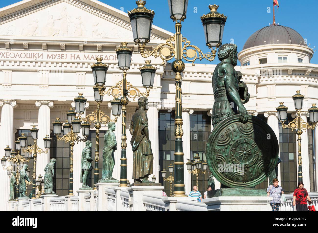 Multiple statues on the Eye Bridge with the archaeological Museum in the background. Skopje, North Macedonia. Stock Photo