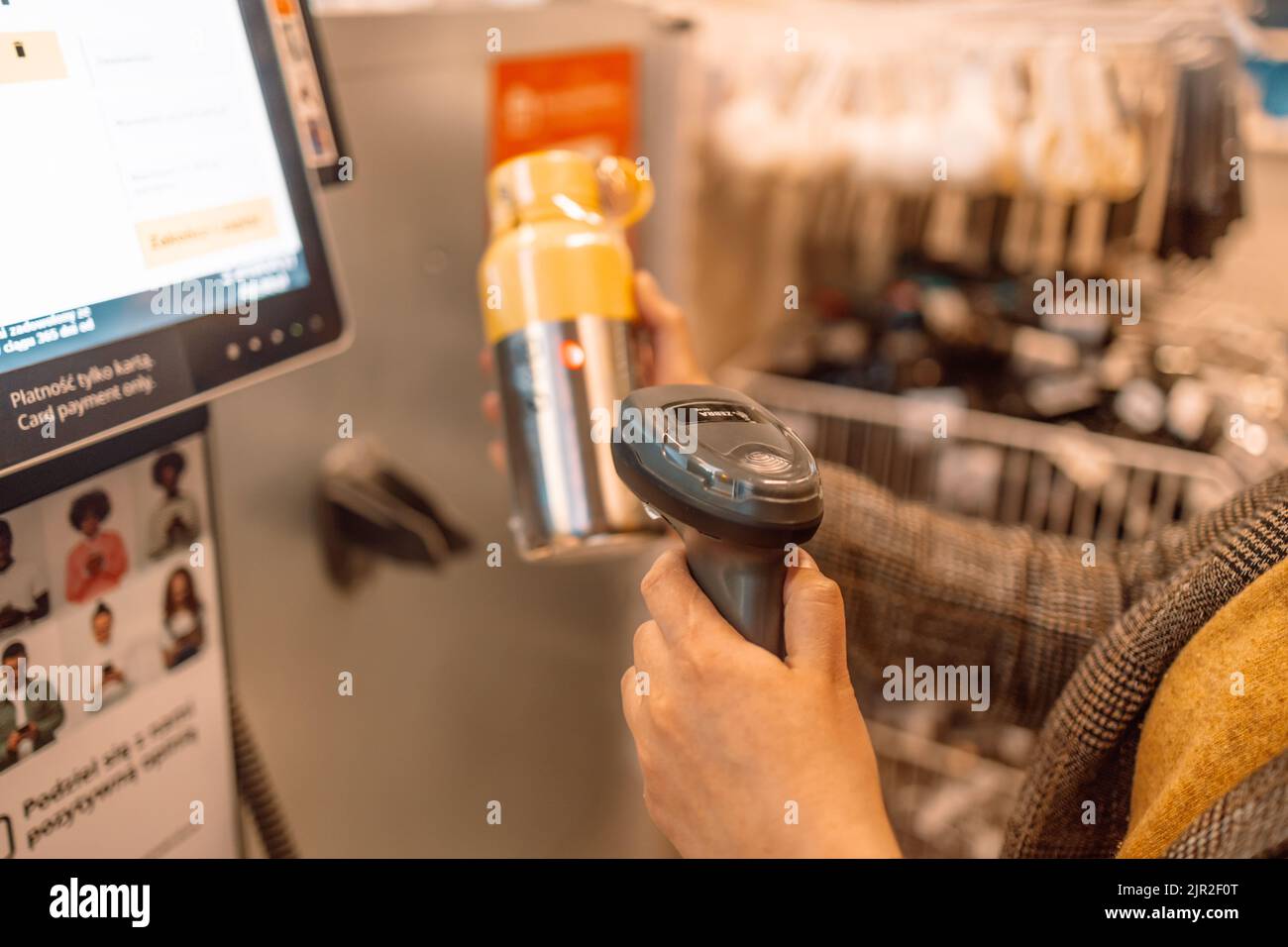 Girl customer scans thermos bottle at the selfservice checkout in the