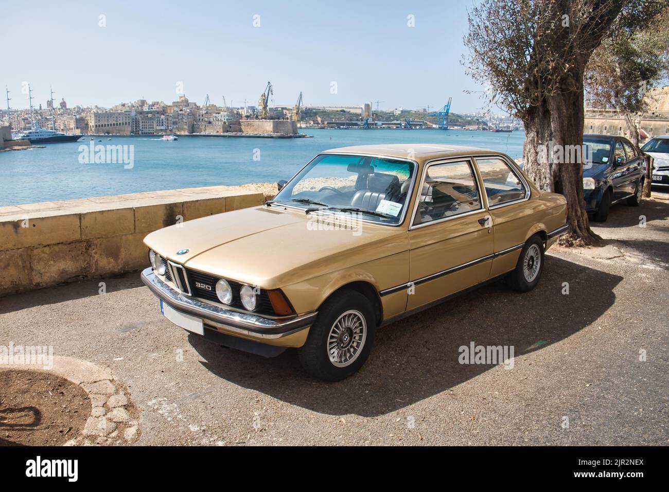 View of an old beautiful BMW 320 metallic gold parked in a street in ...