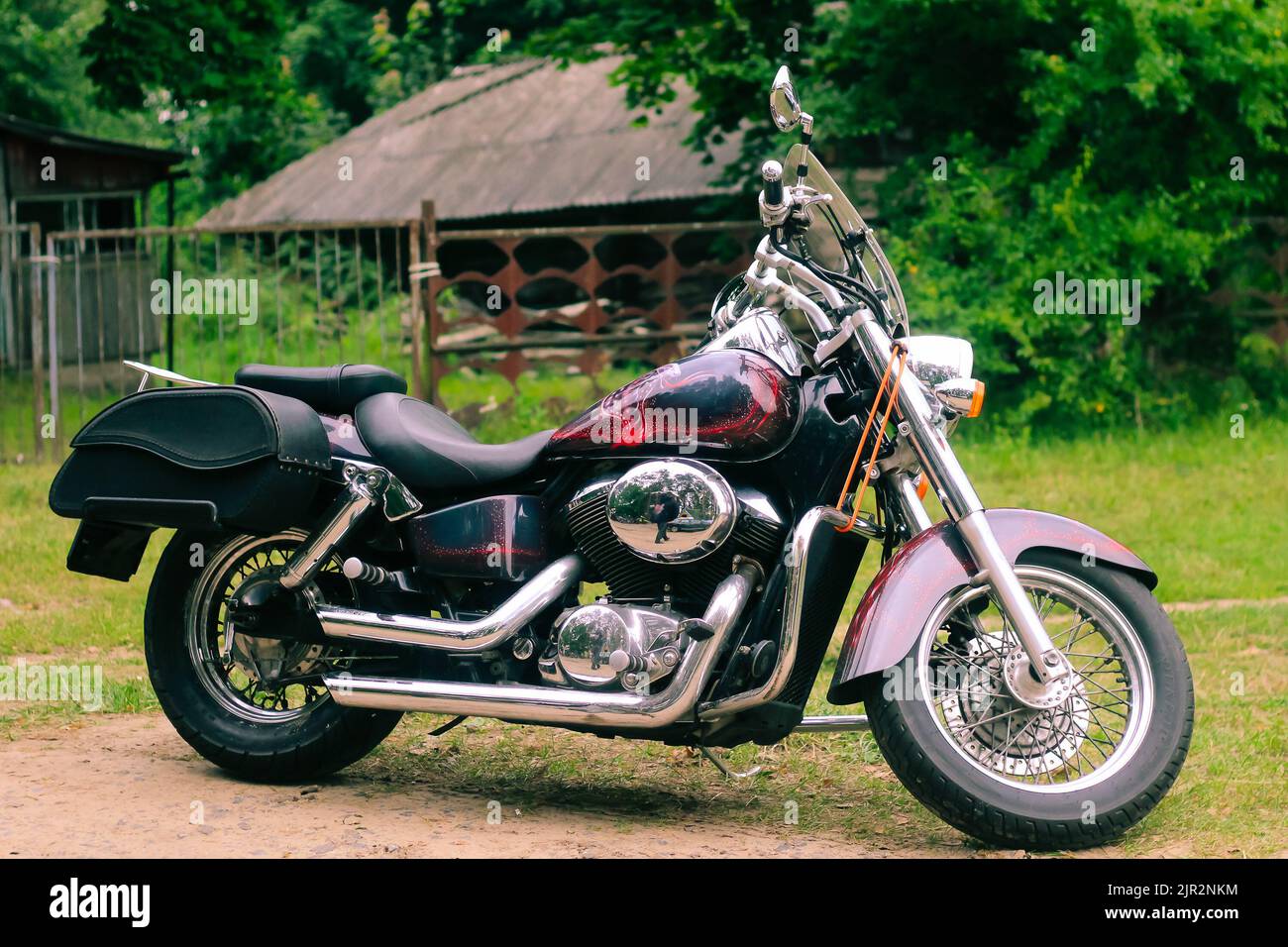 Beautiful powerful motorcycle cruiser stands on a rural road near the house. Freedom and tourism concept. Lida, Belarus - August 25, 2017. Stock Photo