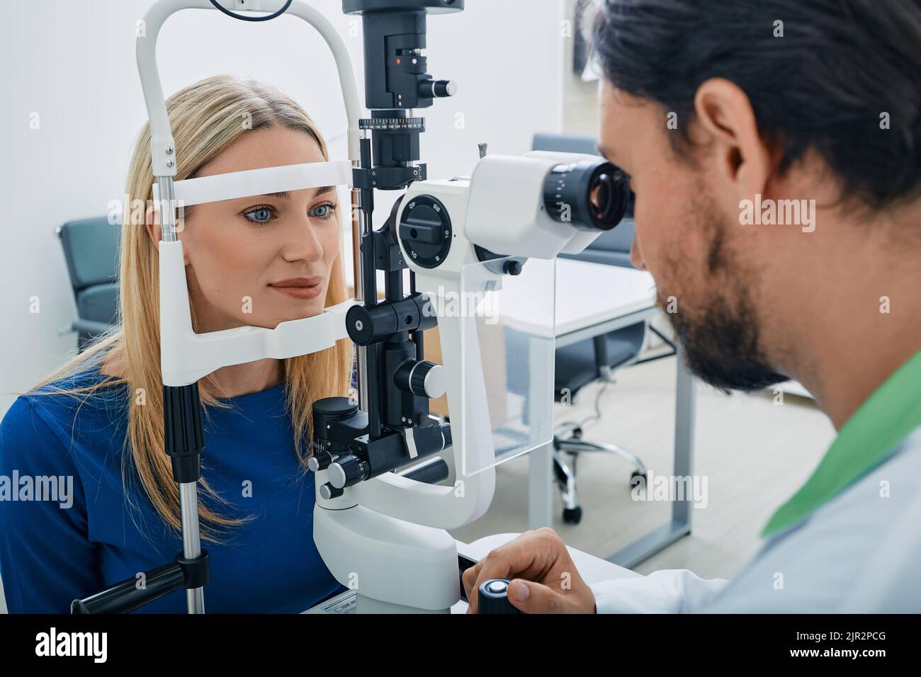 Beautiful woman while eye exam with binocular slitlamp at