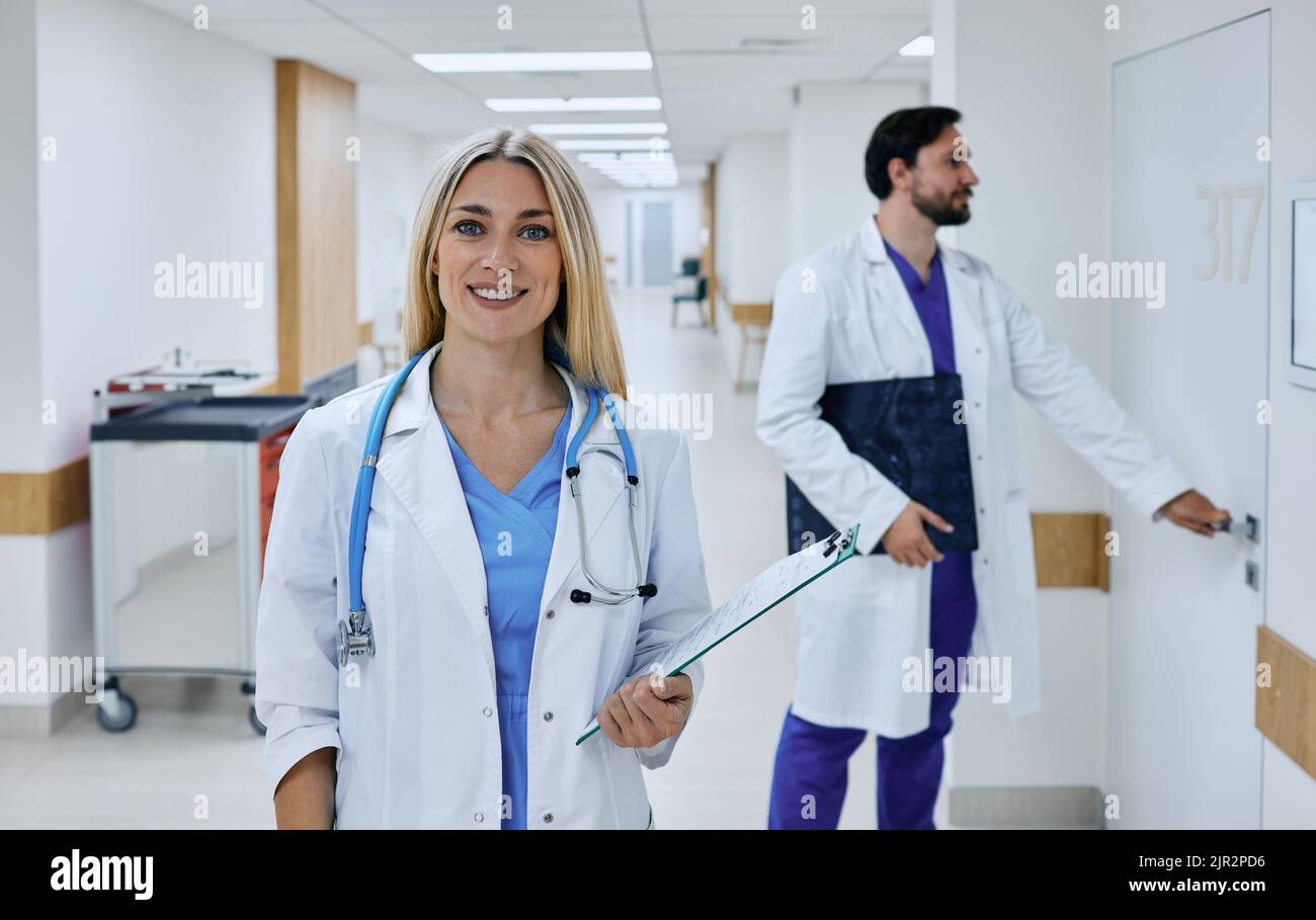 doctor occupation. Beautiful female general practitioner with patient's medical record in her hands standing in a medical clinic, portrait Stock Photo