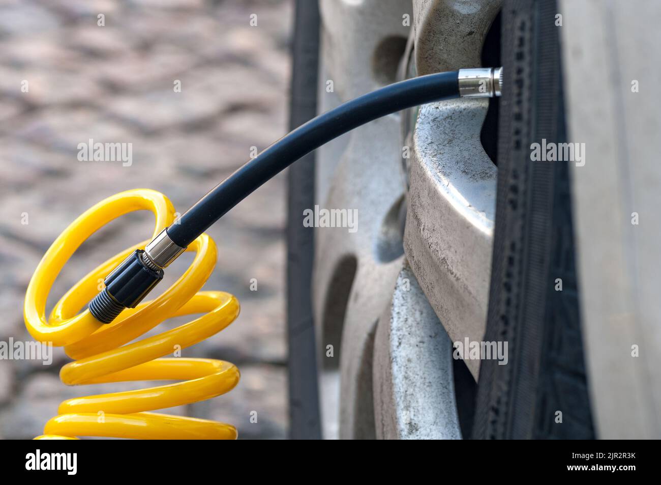 Closeup of inflating car tyre with electric pump Stock Photo