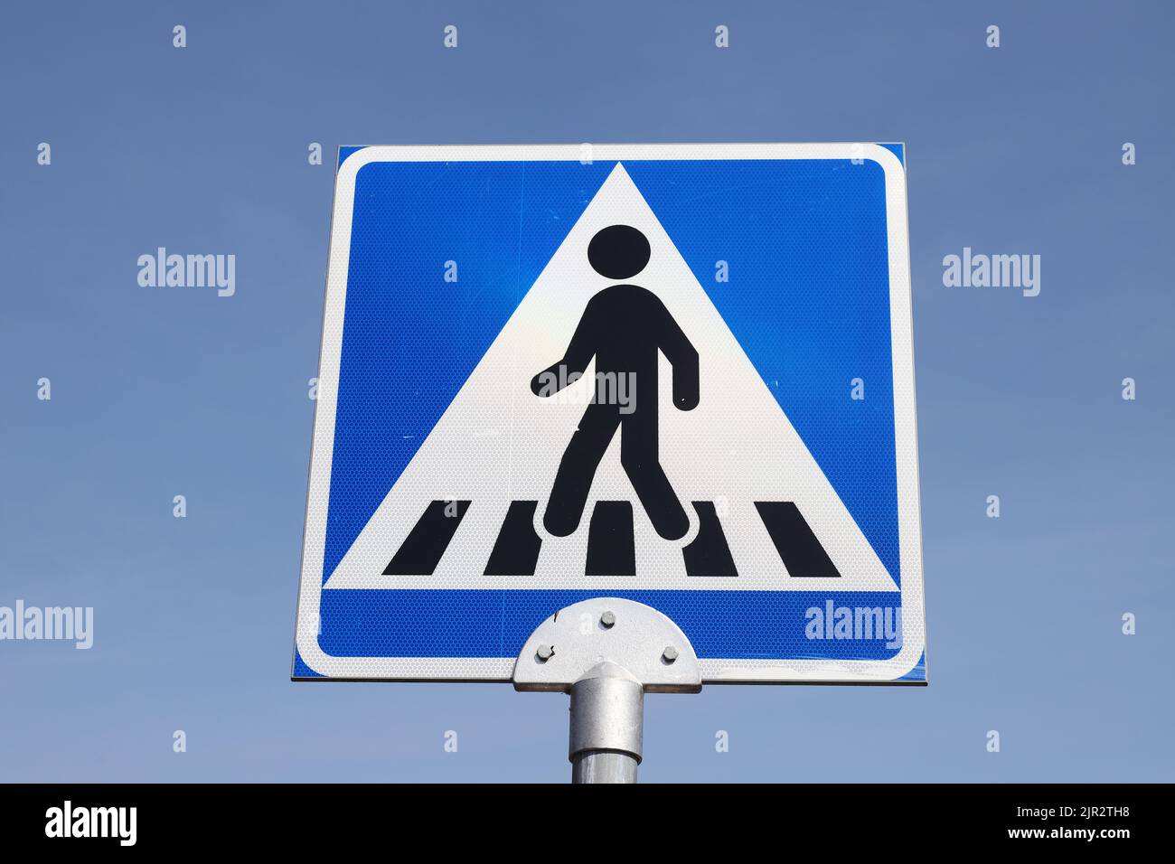 Close-up view of a Finnish genderless pedestrian crossing road sign. Stock Photo