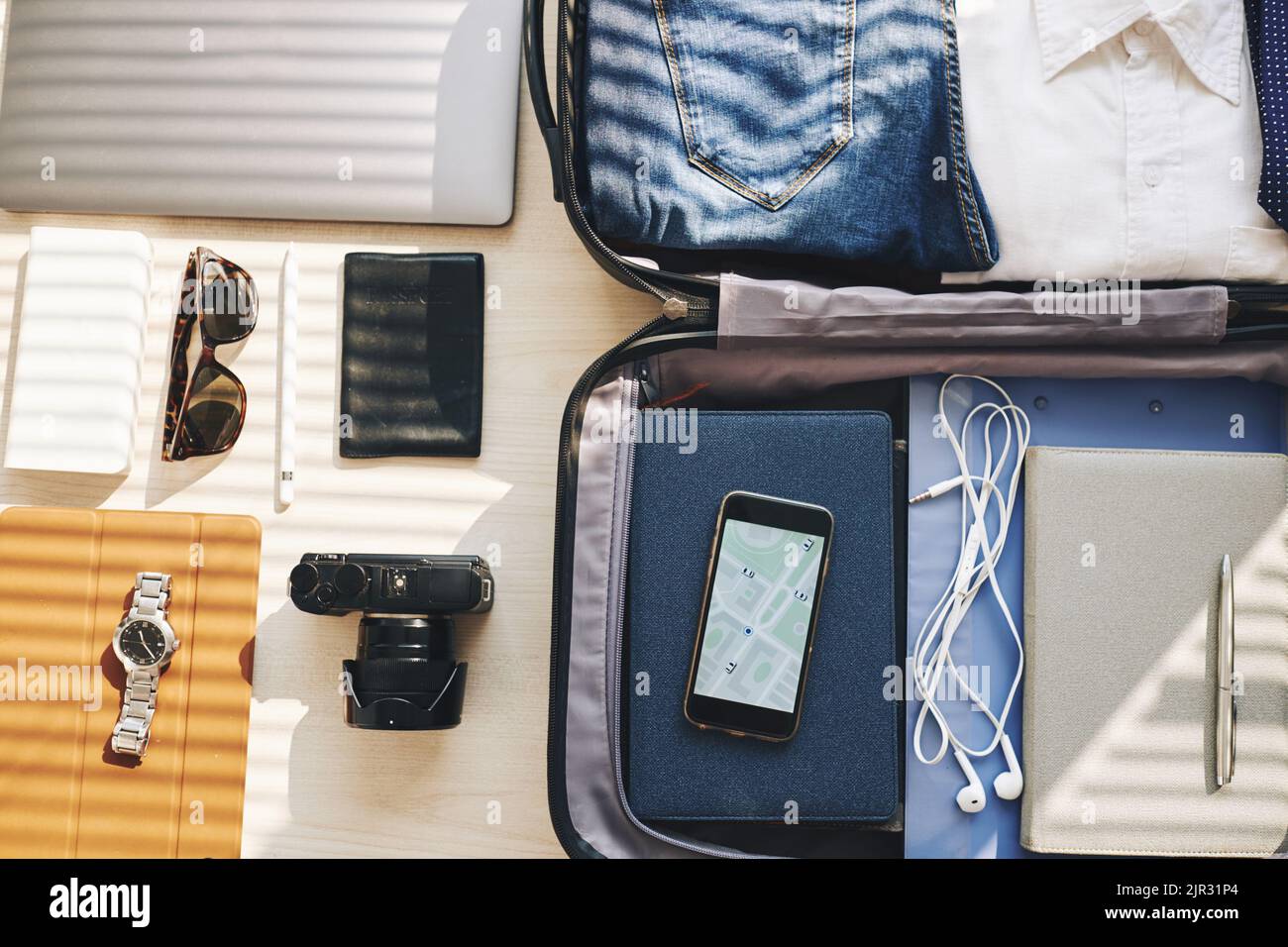 Image of smartphone with map in suitcase and other gadgets on the table ...