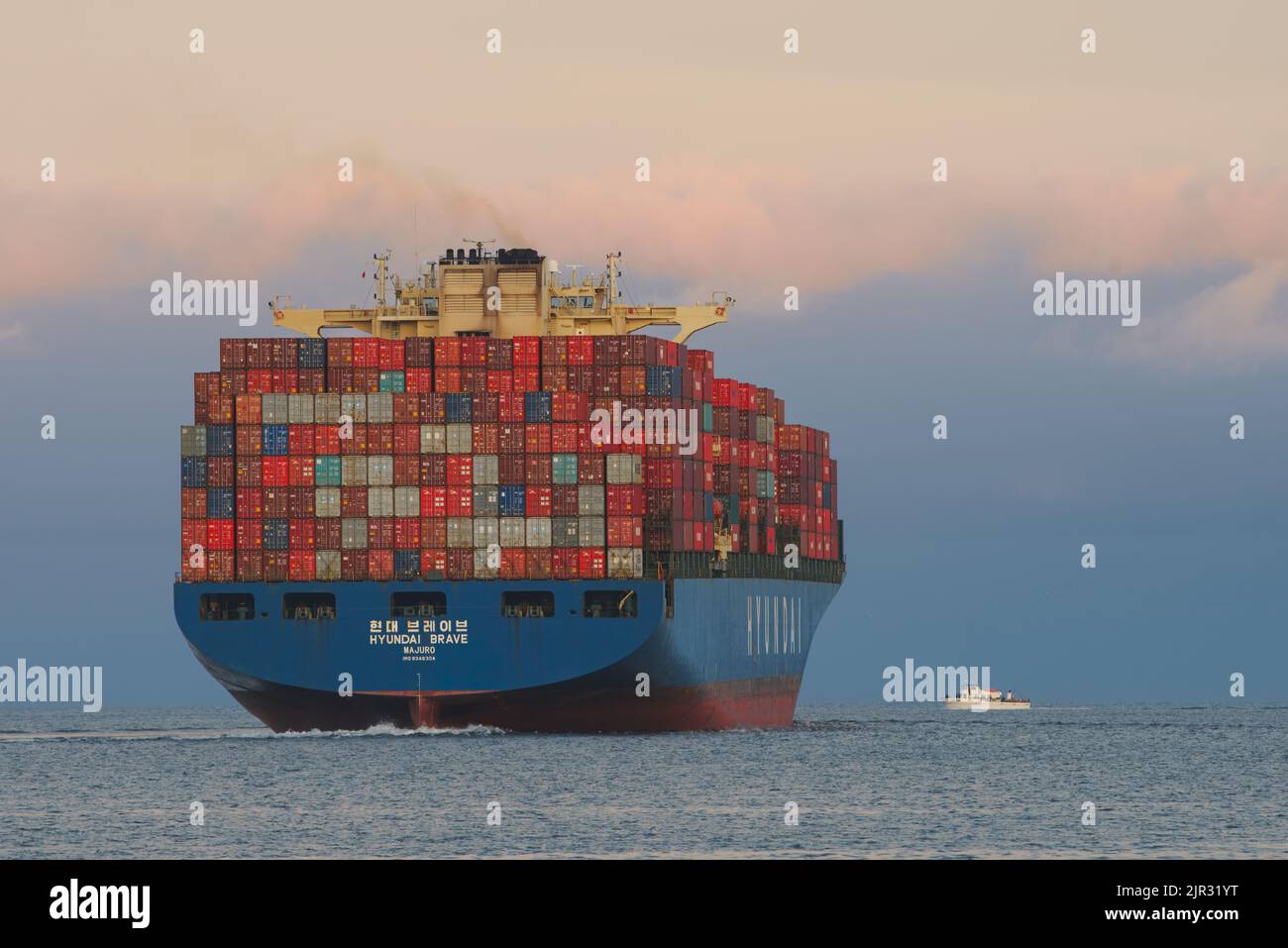 Hyundai container ship shown leaving the Port of Los Angeles, and a small cruise boat in the Los Angeles Harbor, California, USA, on August 17, 2019. Stock Photo
