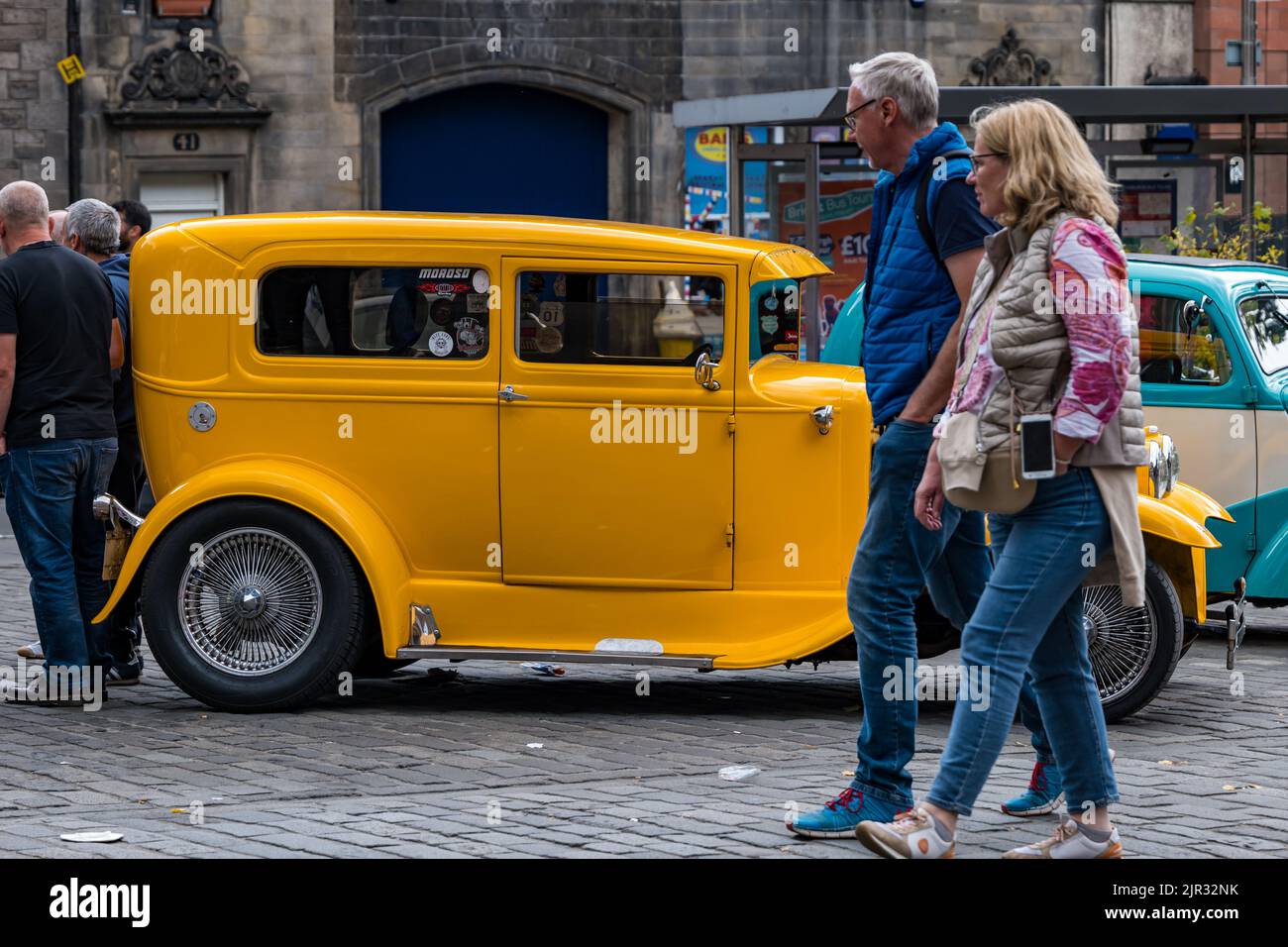 People admiring a vintage yellow 1930 Ford Model A on display in the Grassmarket, Edinburgh, Scotland, UK Stock Photo