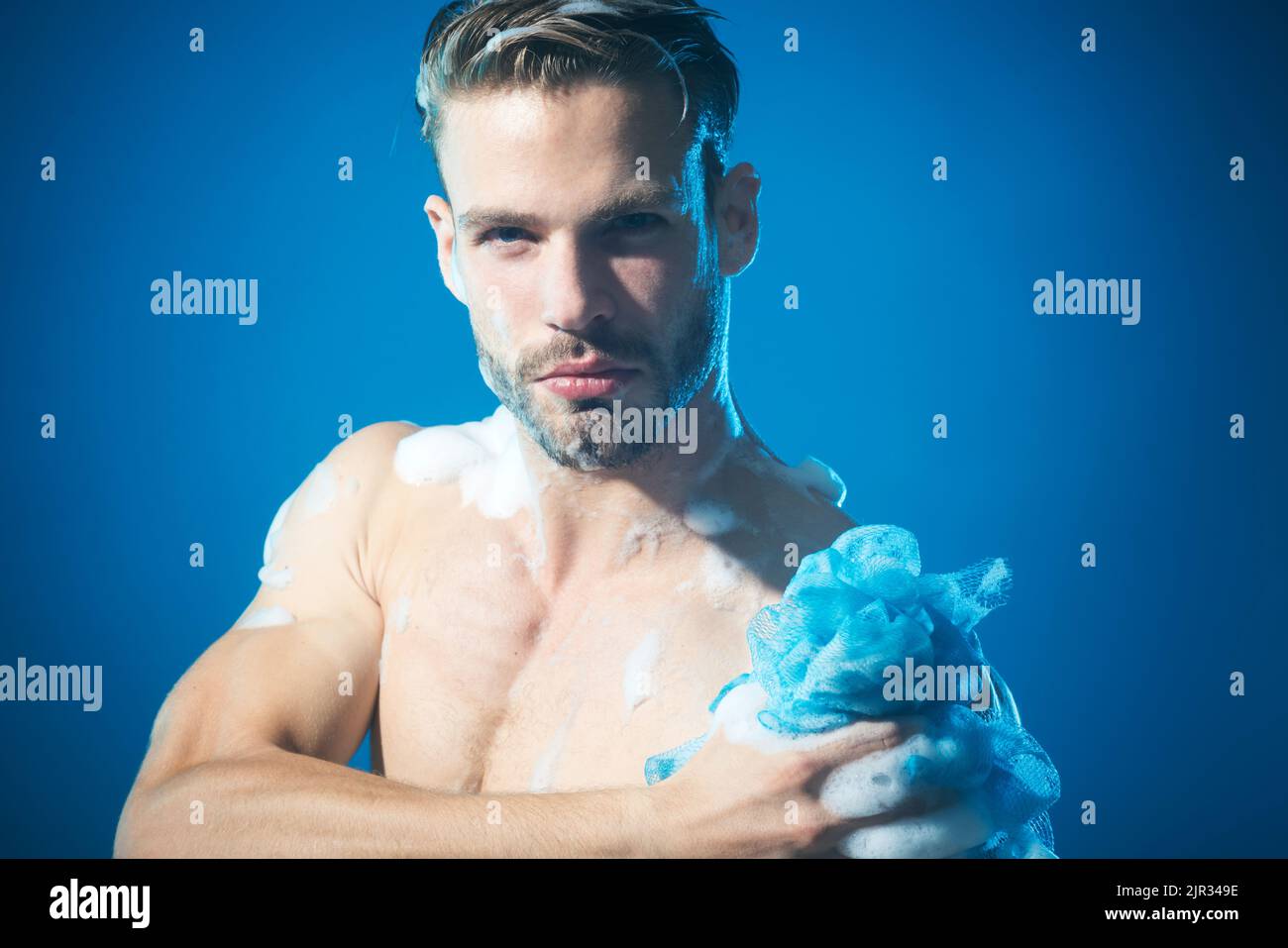 Muscular man taking refreshing morning shower. Sexy guy in bathroom Relaxing time. Bodycare. Stock Photo