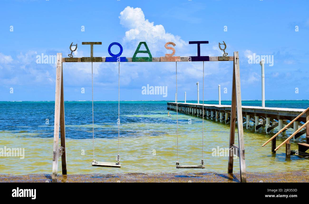 A set of swings over the water at a beach bar on Ambergris Caye, San