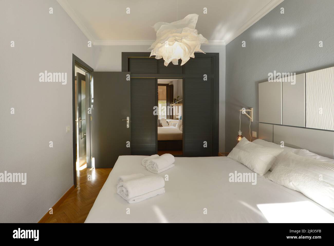 Bedroom with double bed, wardrobe with gray doors and