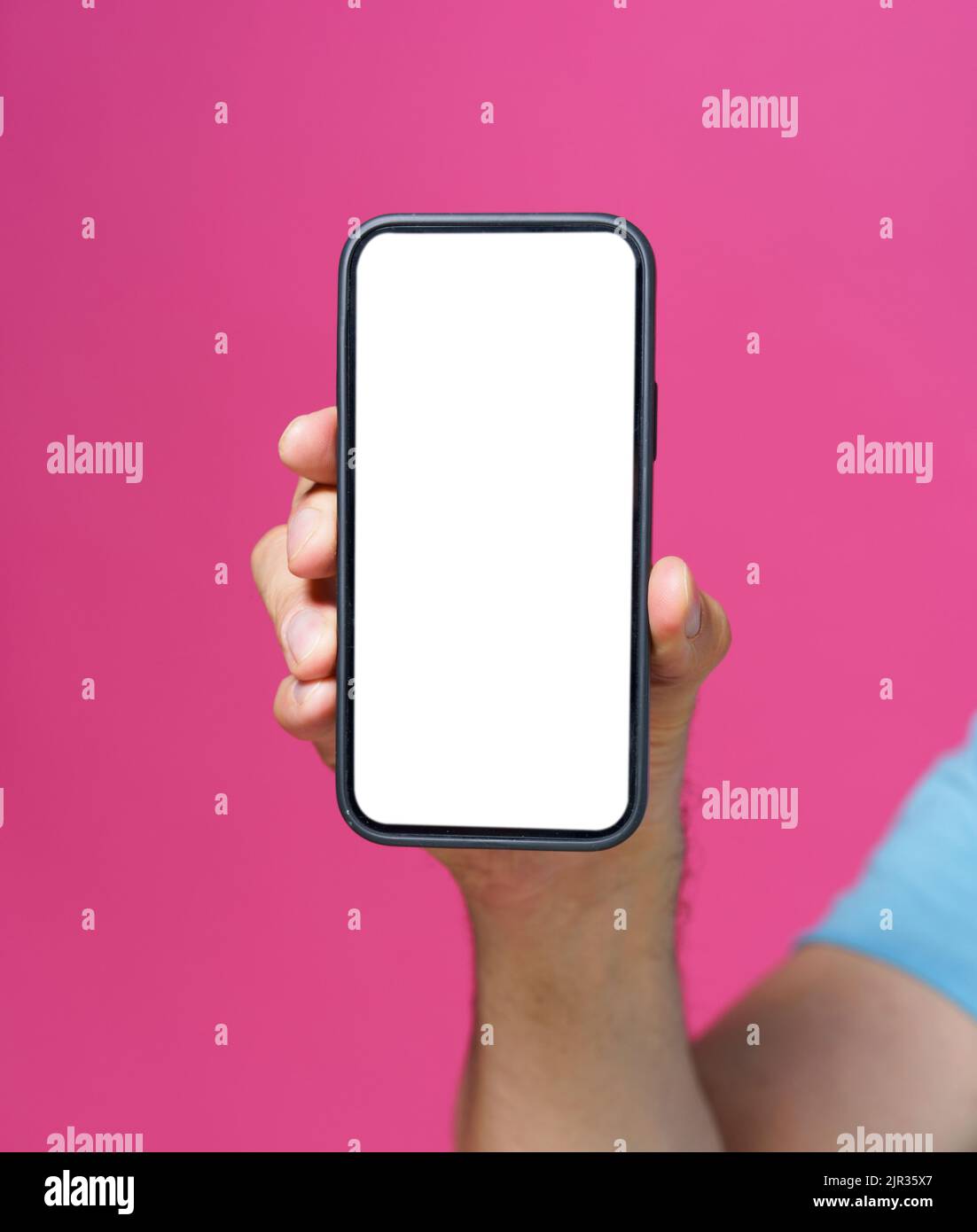 Close up man hand holding smartphone with white blank screen and black phone case. Isolated on pink background. Mobile phone frameless design concept for mobile app advertising. Copy space.  Stock Photo