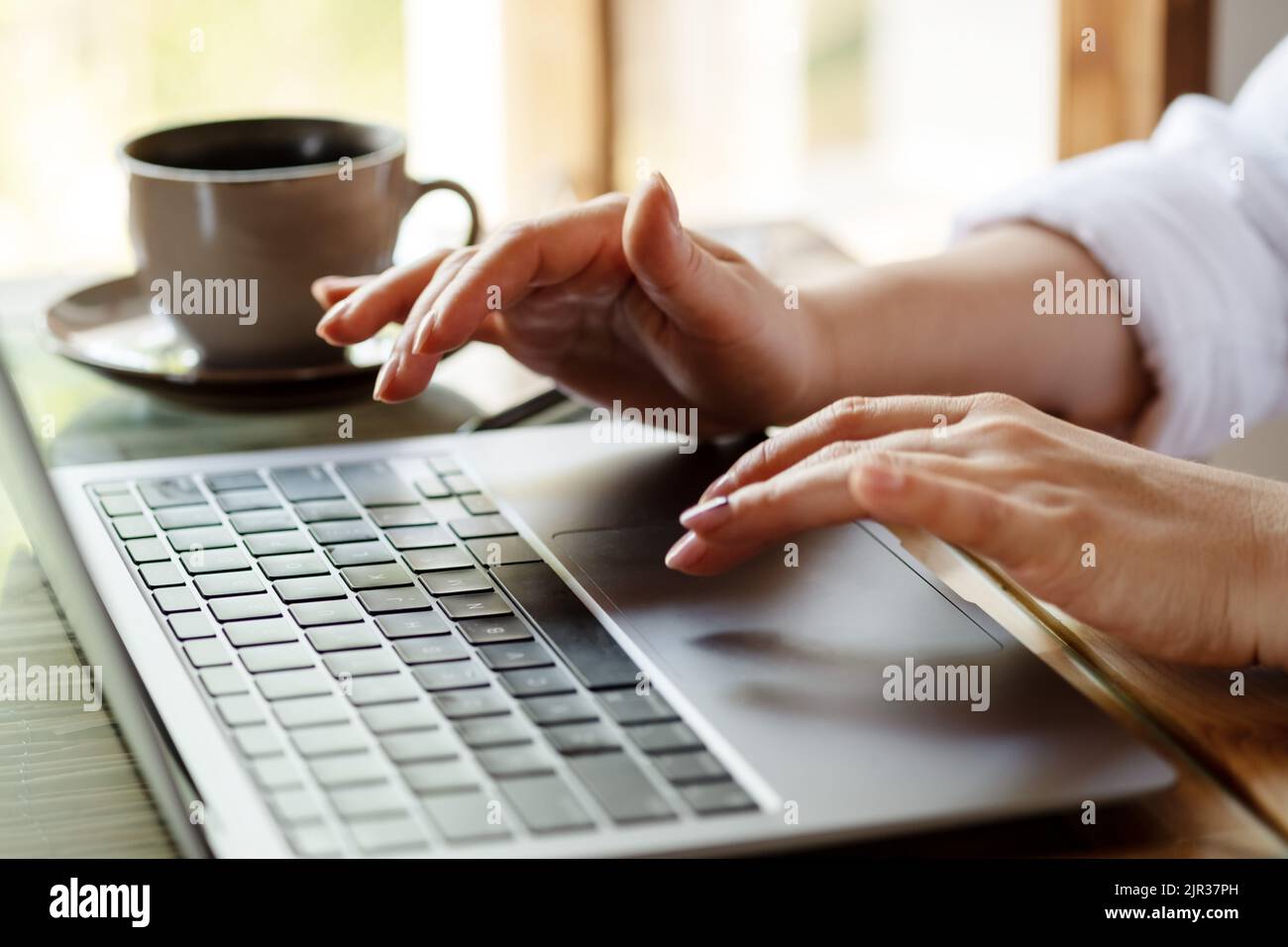 Close up image of woman hands typing on laptop computer keyboard and surfing the internet on office table, online, working, business and technology, internet network communication concept.  Stock Photo