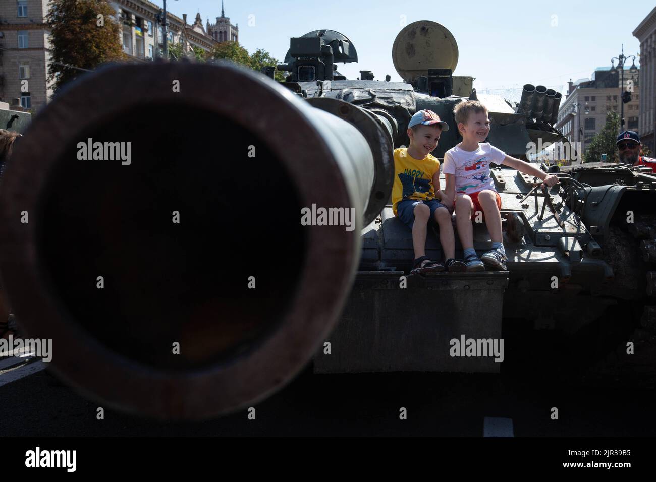Children sit on a destroyed Russian tank displayed on the main street Khreshchatyk as part of the upcoming celebration of the Independence Day of Ukraine amid Russia's invasion of Ukraine in central Kyiv. Stock Photo