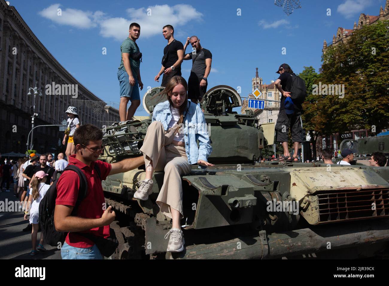 People pose next to a destroyed Russian tank displayed on the main street Khreshchatyk as part of the upcoming celebration of the Independence Day of Ukraine amid Russia's invasion of Ukraine in central Kyiv. Stock Photo