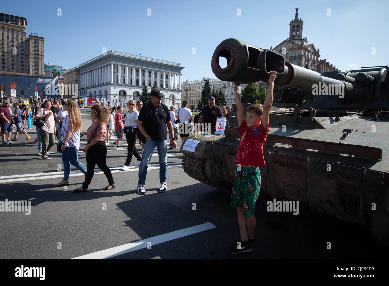 A boy hangs on the cannon of a destroyed Russian tank displayed on the main street Khreshchatyk as part of the upcoming celebration of the Independence Day of Ukraine amid Russia's invasion of Ukraine in central Kyiv. Stock Photo