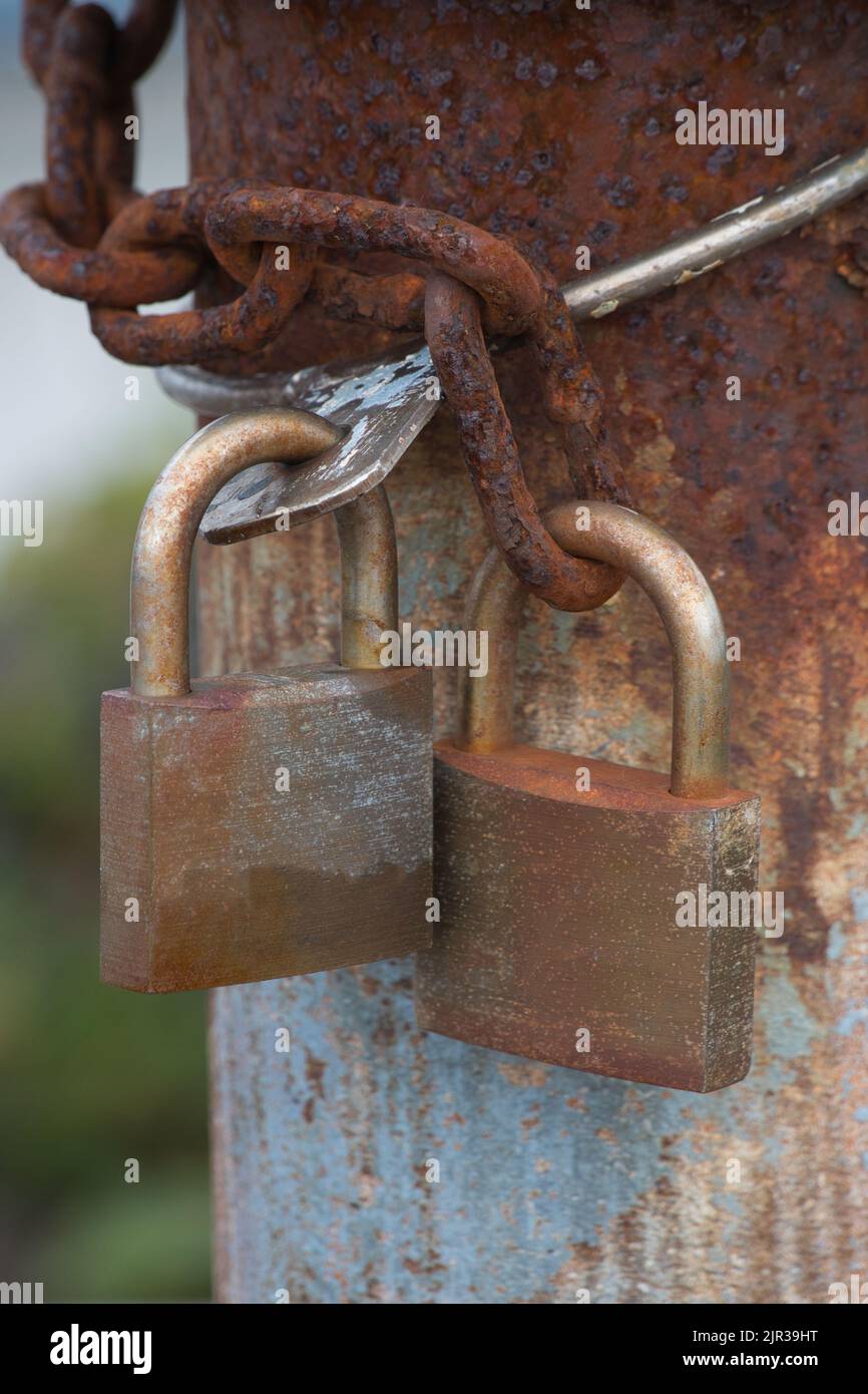 Two locked rusty metal padlocks Stock Photo
