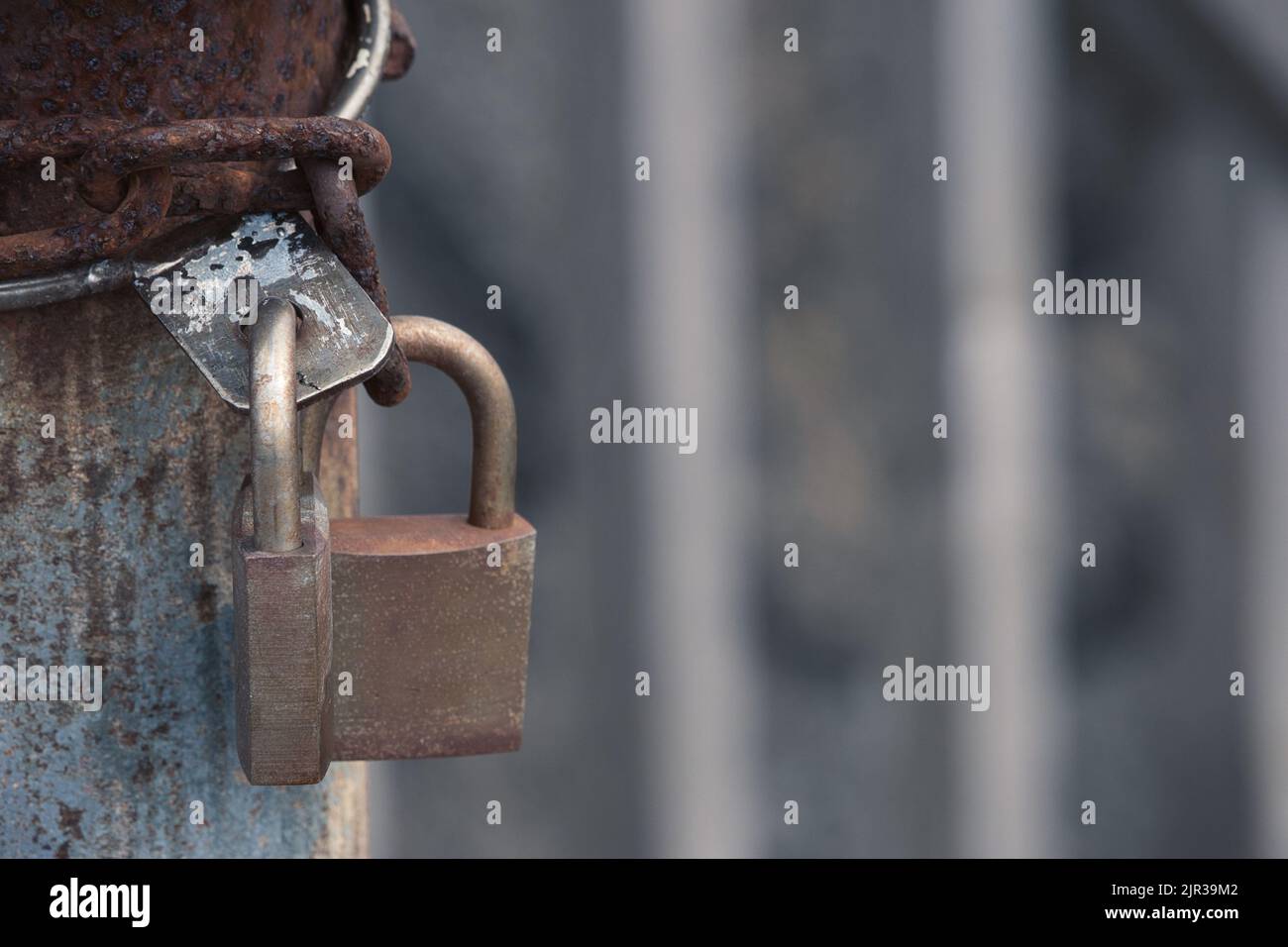 Two locked padlocks and cage bars Stock Photo