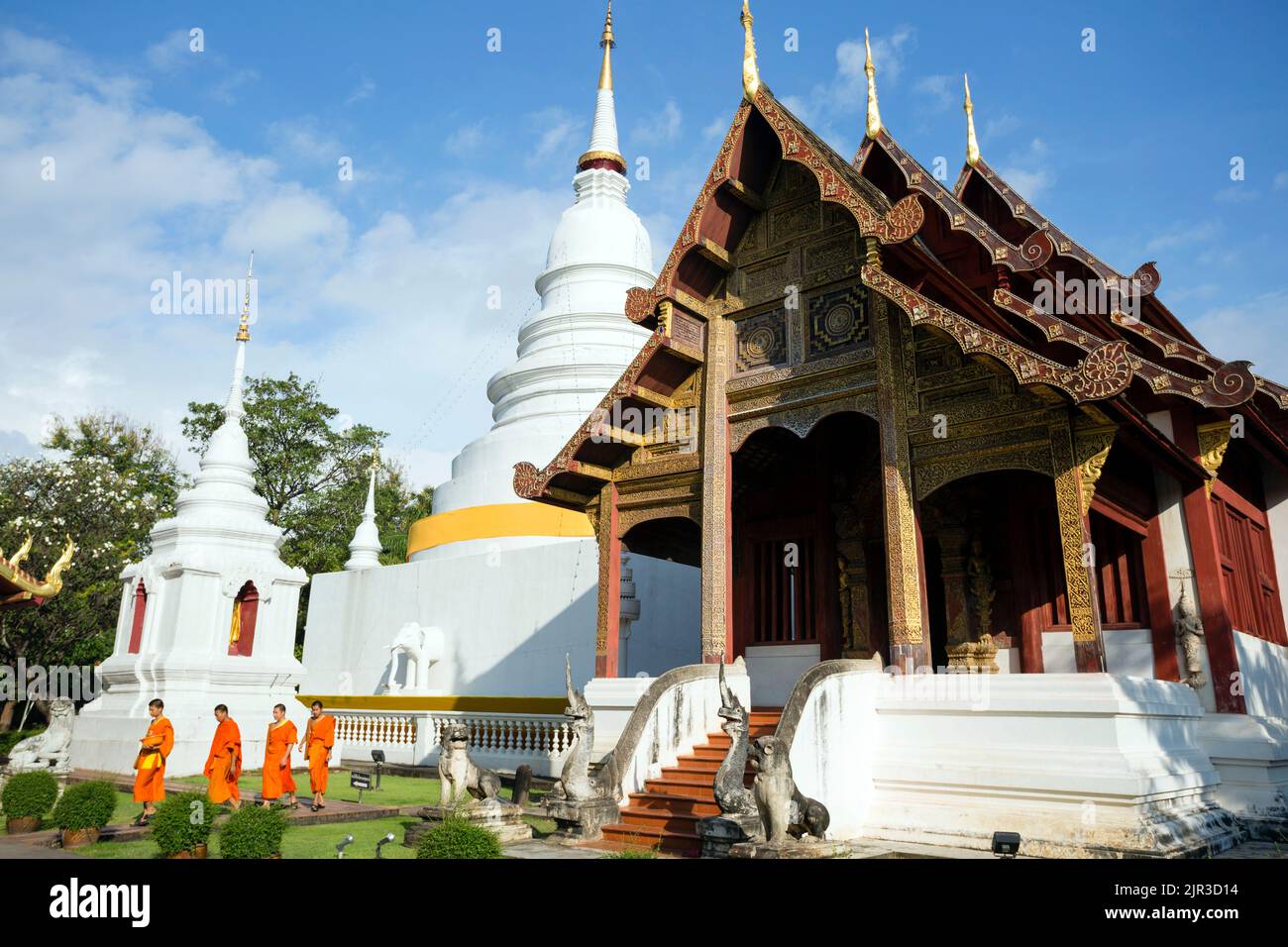 Chiang Mai, Thailand - November 14, 2013: Buddhist monks walking through the exterior of Wat Phra Singh located in Chiang Mai, Thailand. Stock Photo