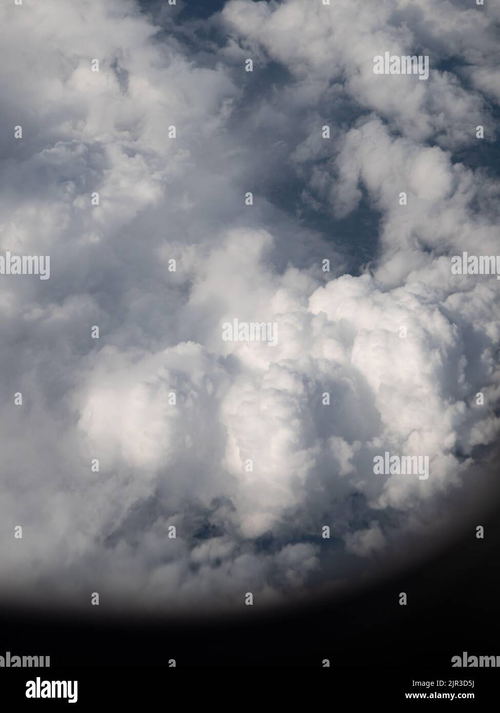 View of big white puffy clouds taken from airplane window Stock Photo
