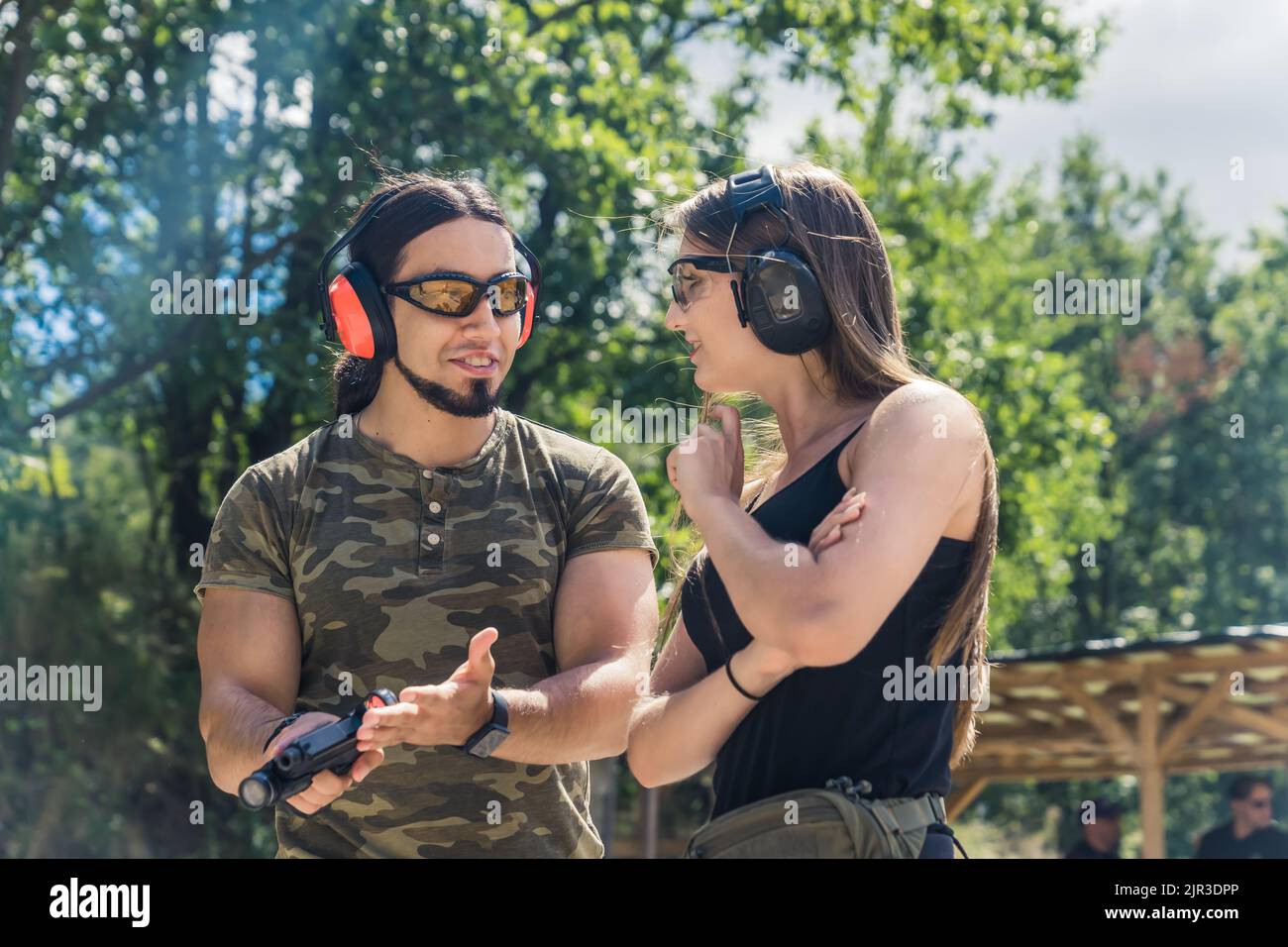 White man and woman in safety goggles and headphones talking during