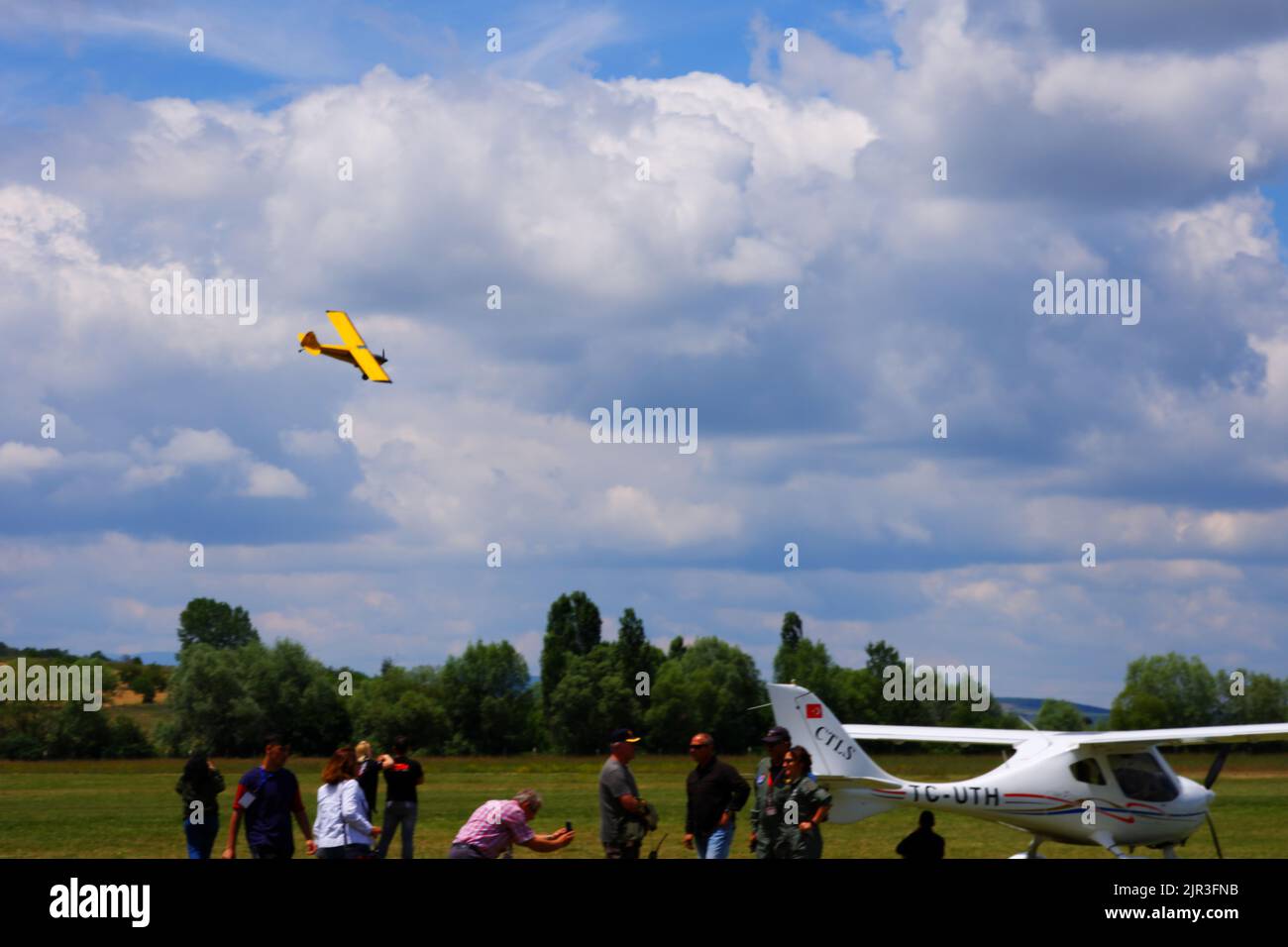 Single engine yellow air plane flying at low altitude close to the ground Stock Photo