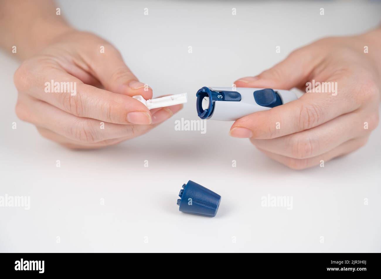Caucasian woman inserts a needle into a lancet pen Stock Photo Alamy