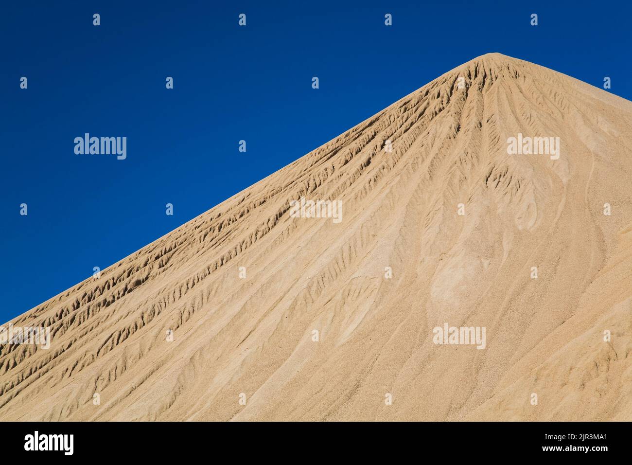 Mound of tan colored sand in commercial sandpit. Stock Photo