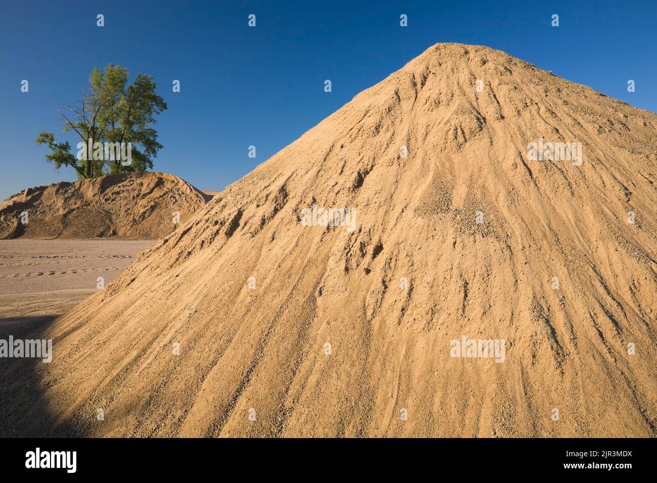 Mounds of sand in a commercial sandpit. Stock Photo