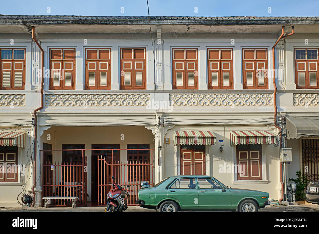 A row of Sino-Portuguese or Peranakan houses in Dibuk Road in the Old Town area of Phuket Town, Phuket, Thailand, an old car parked in front Stock Photo