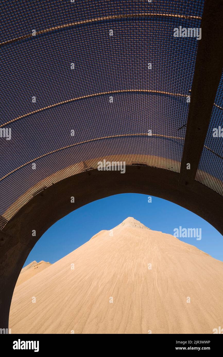 Mound of sand through a metal screener in commercial sandpit. Stock Photo