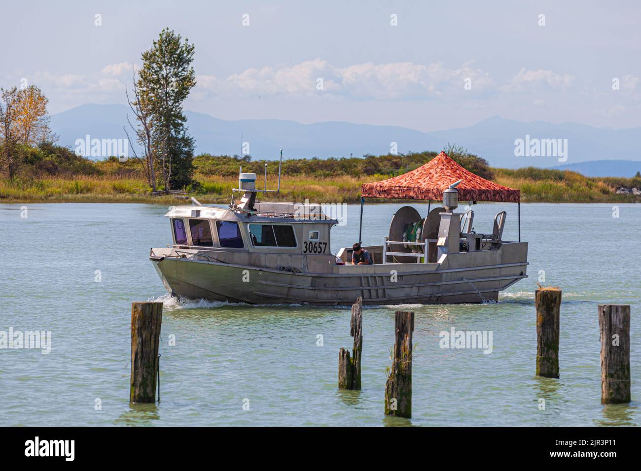 Commercial fishing vessel returning to Steveston with a shady tent over the deck in British Columbia Canada Stock Photo