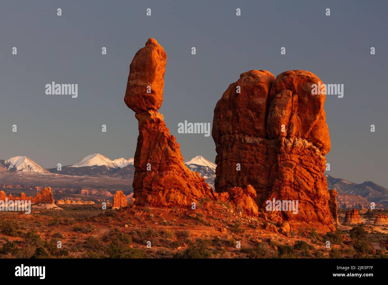 Balanced Rock and the La Sal Mountains, at sunset, Arches National Park, Moab, Utah Stock Photo
