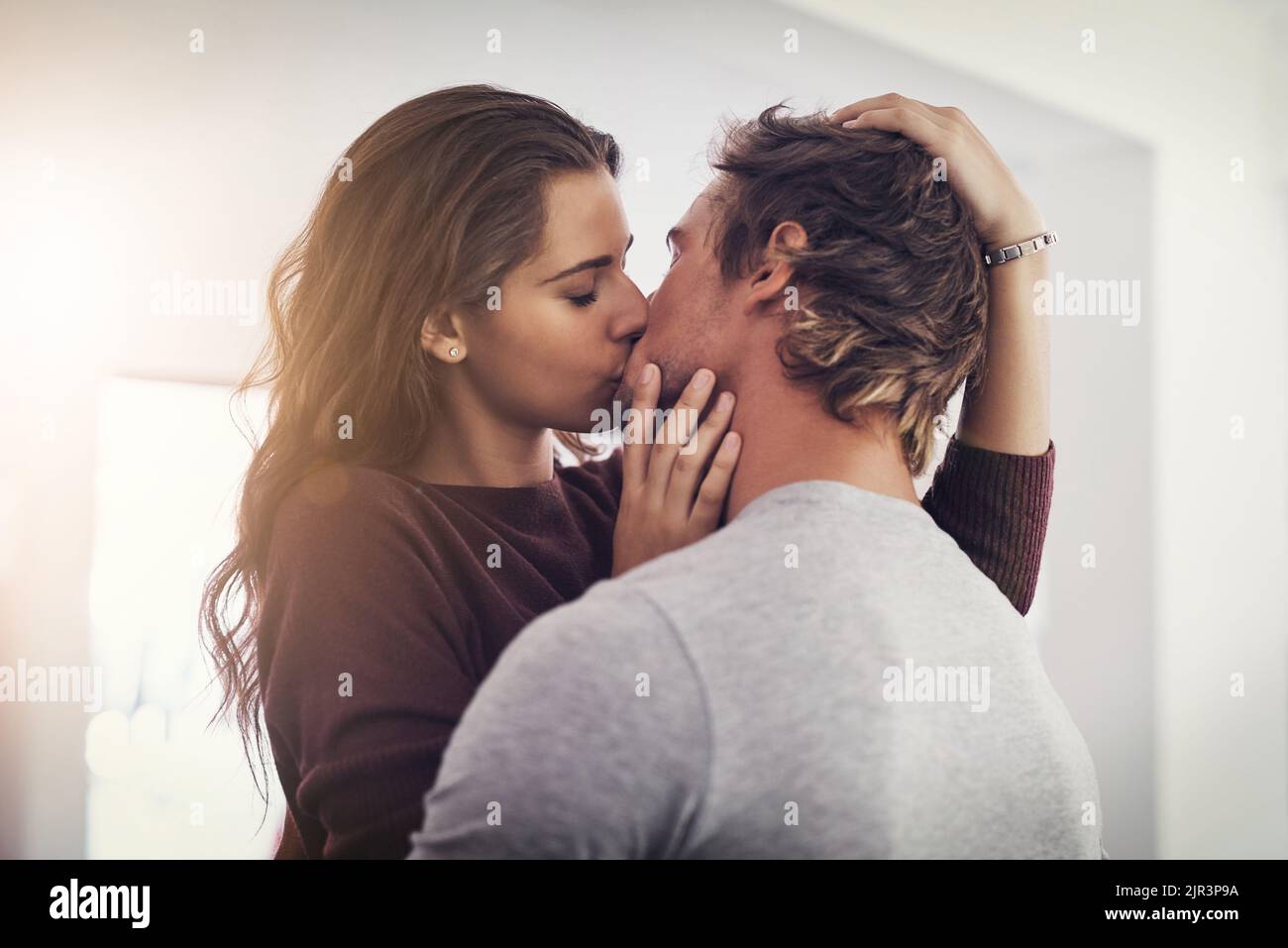 He gives the best kisses. a young couple making out in the kitchen. Stock Photo