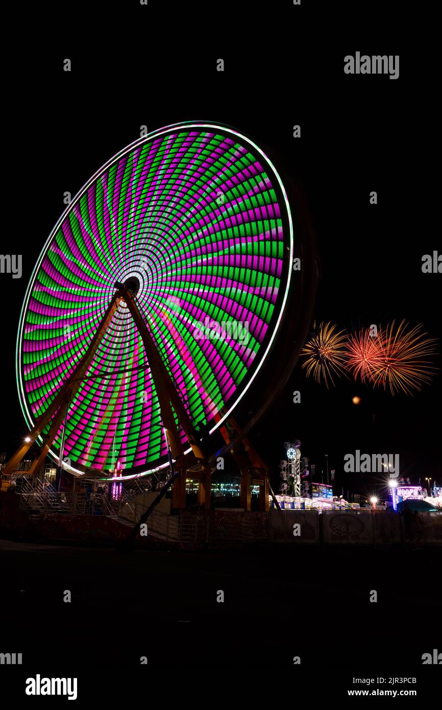 Fireworks and lights on a spinning ferris wheel at night, Delaware State Fair, Harrington, Delaware Stock Photo