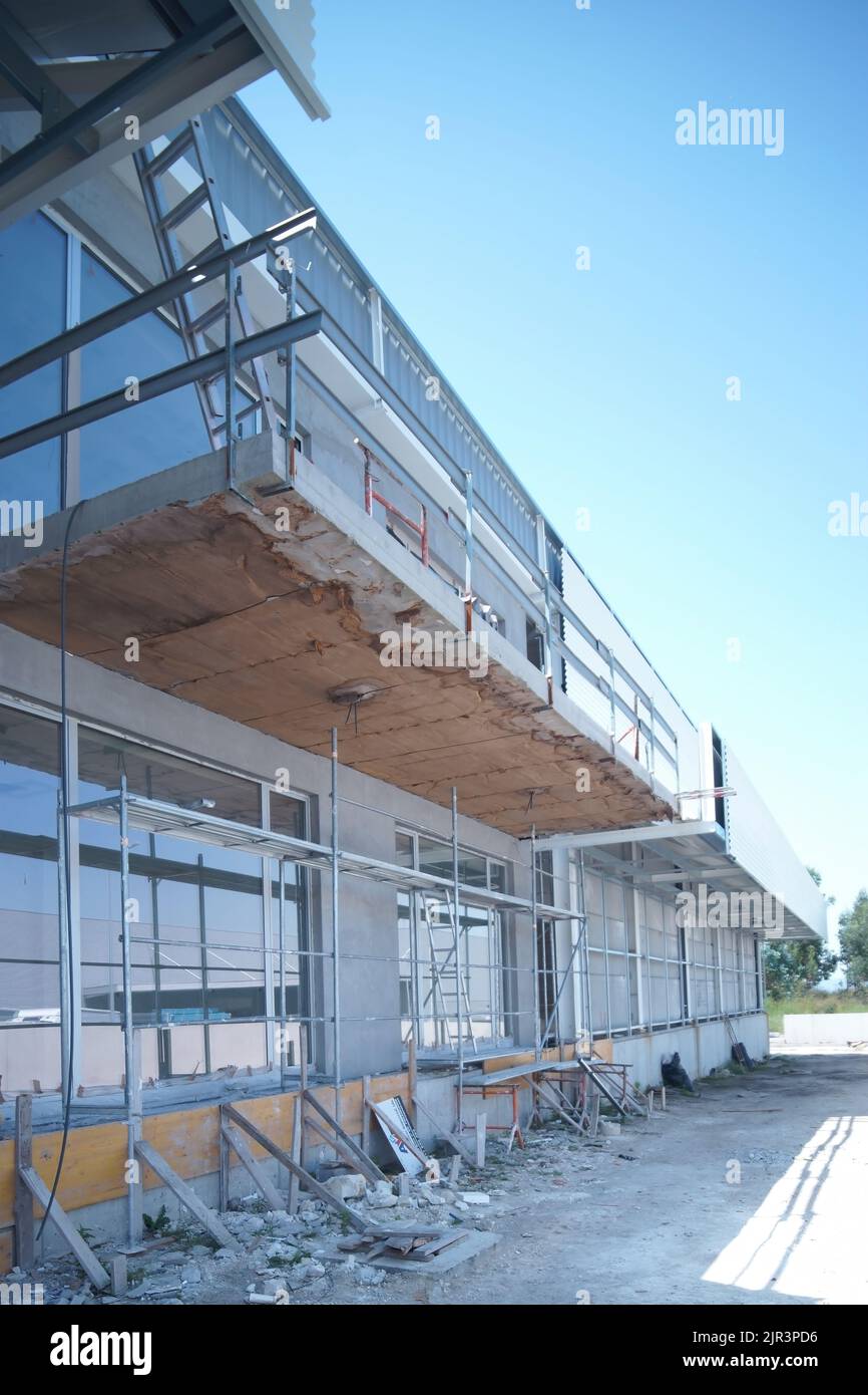 two people walking, in an industrial building repair, all white, steel