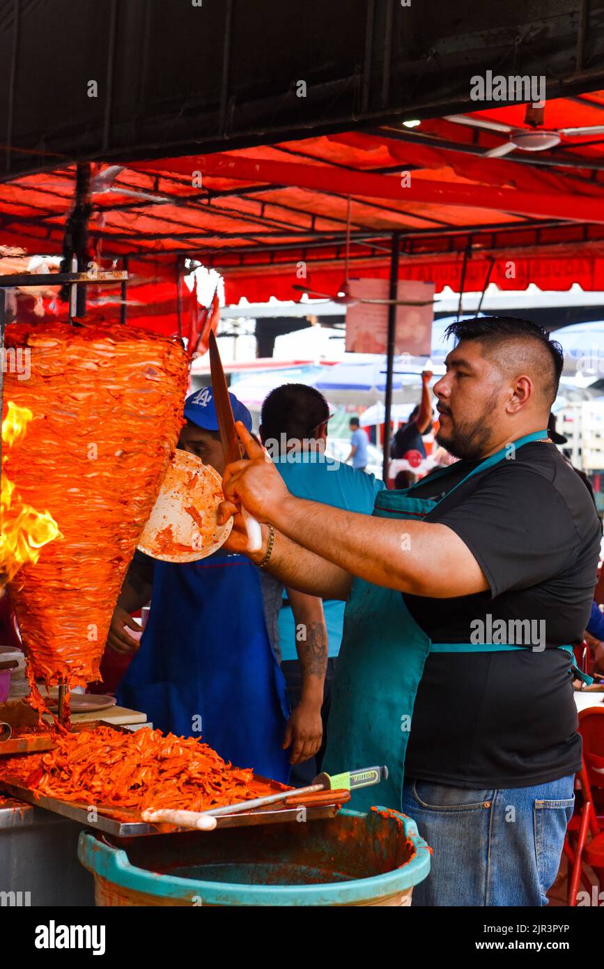 Man preparing Al pastor meat (Mexican version of Lebanese Shawarma