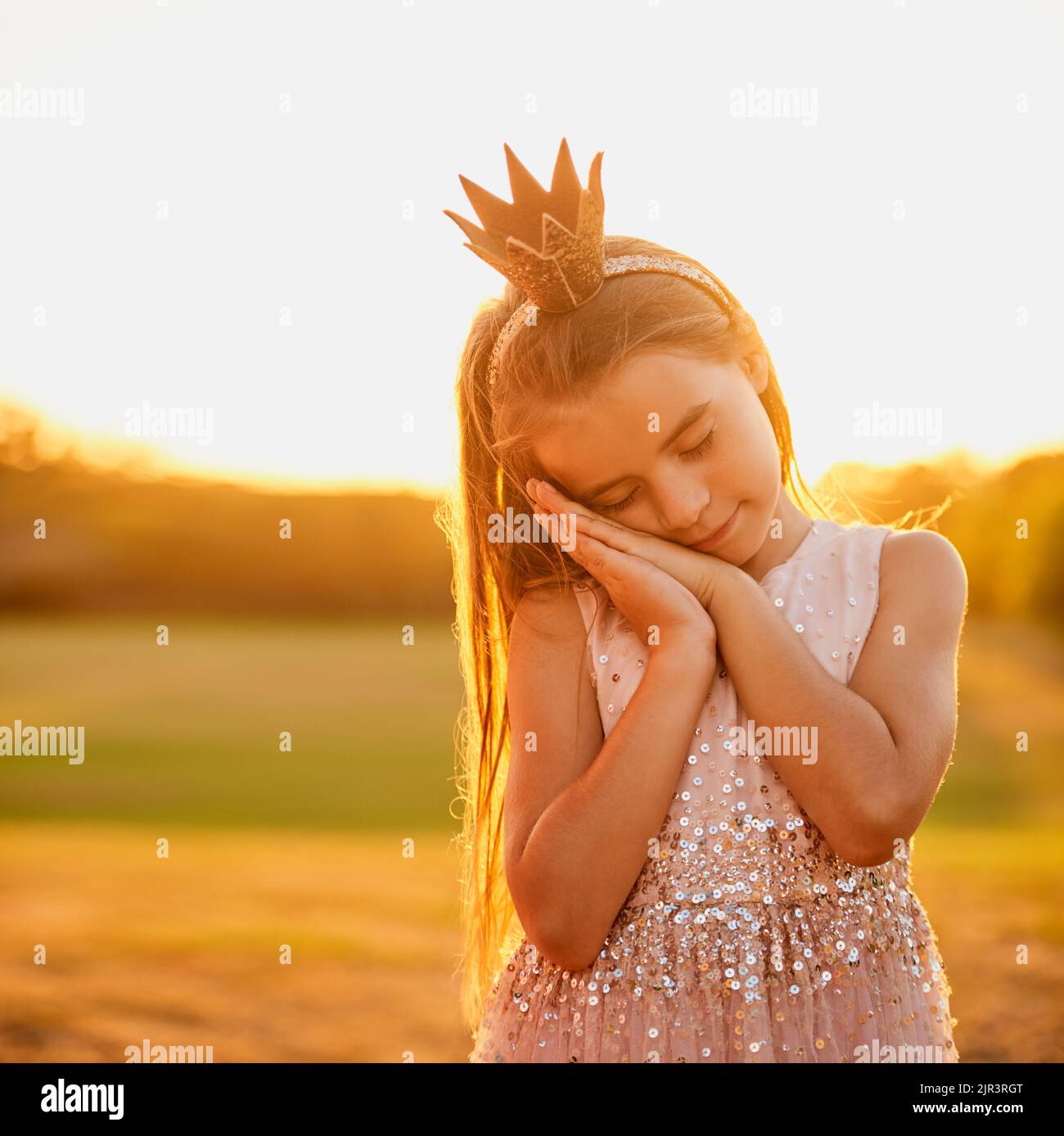 She likes to pretend to sleep while standing. an adorable little girl playing outdoors. Stock Photo