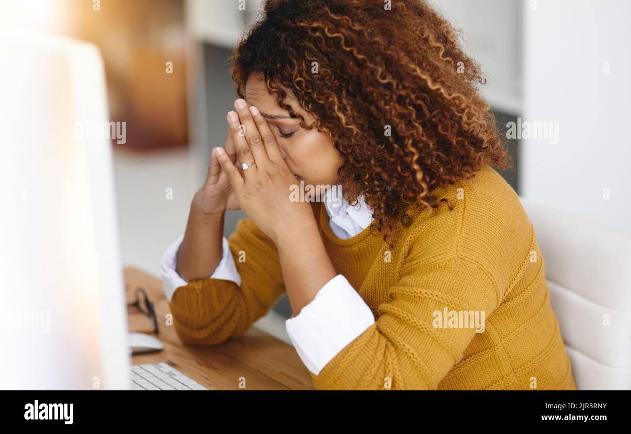 I can do this. a stressed young businesswoman sitting and working in the office at work. Stock Photo