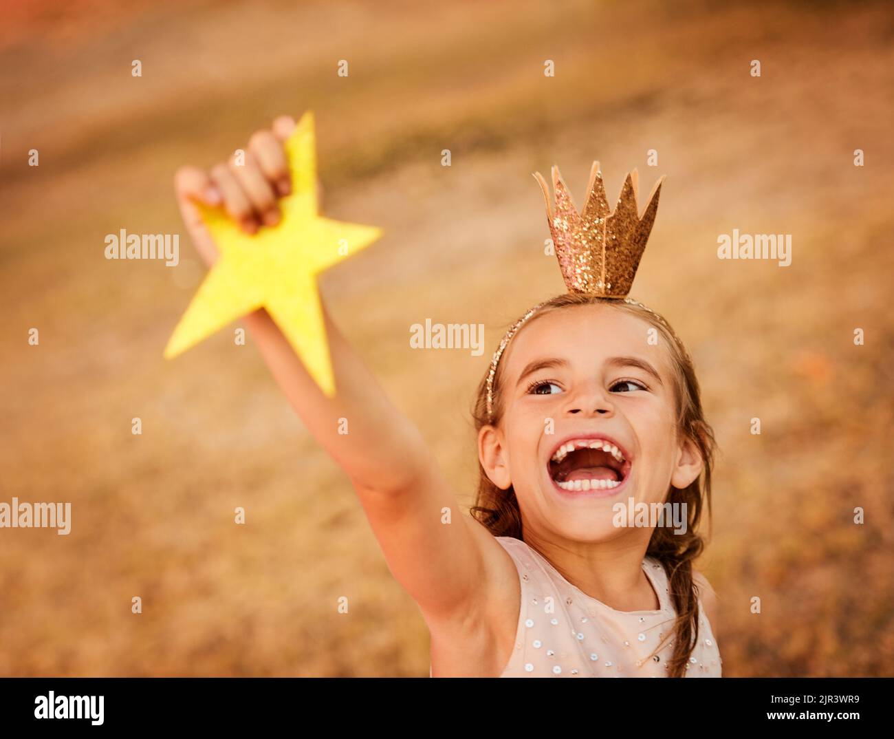 Here you go sky you can have your star back. an adorable little girl playing outdoors. Stock Photo