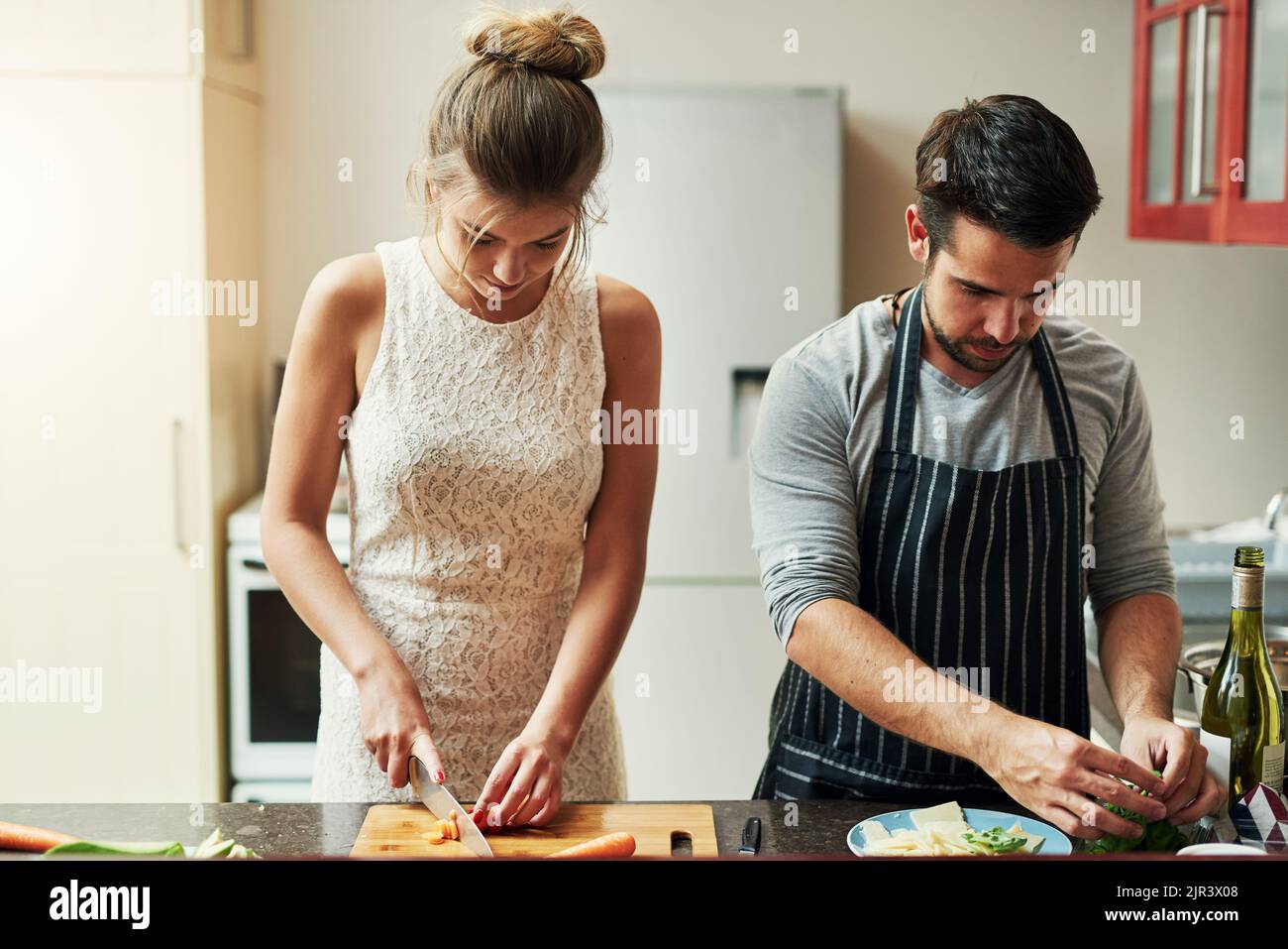 Cooking with love provides food for the soul. an affectionate young couple preparing food together at home. Stock Photo