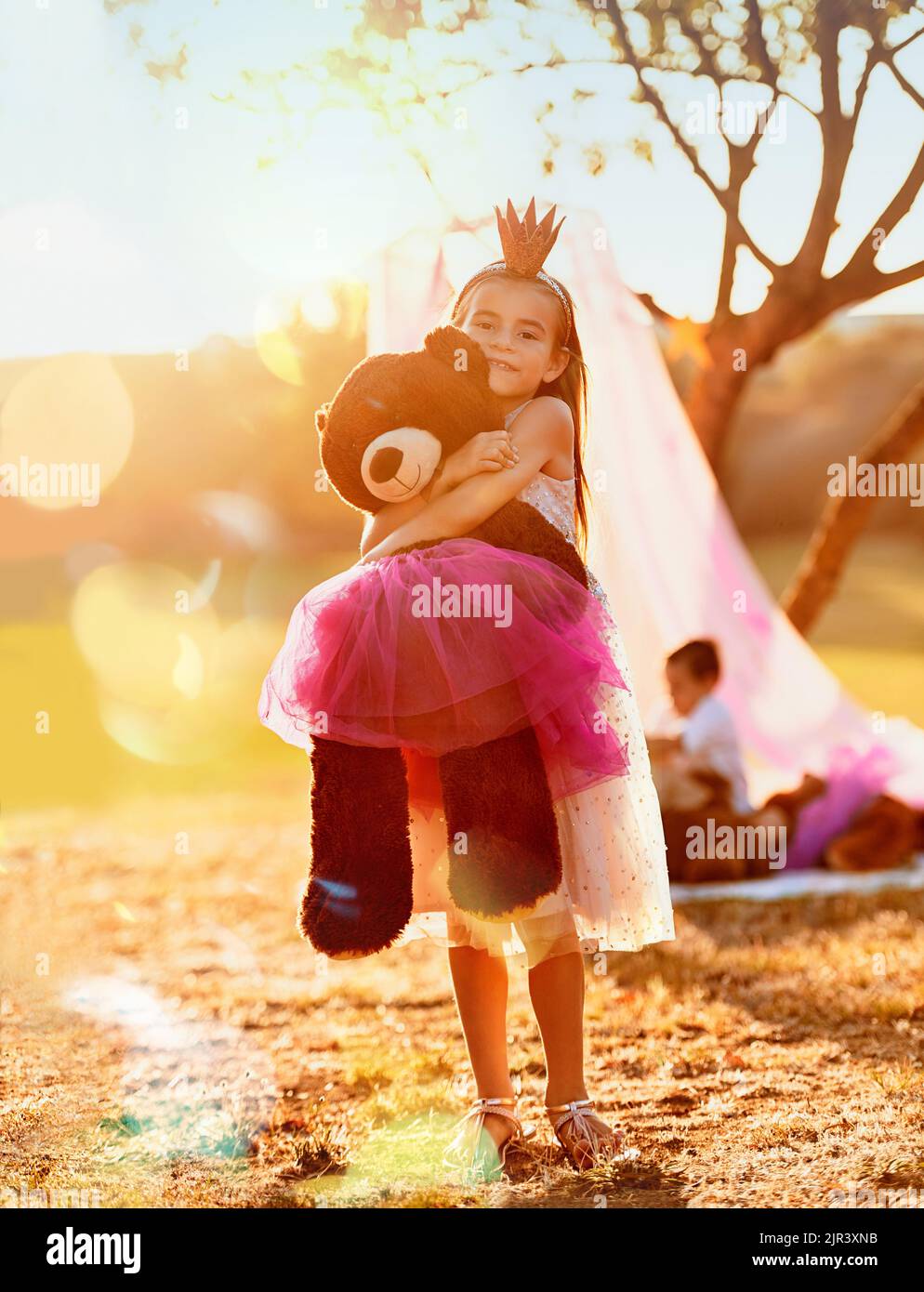 This is the imagination nation. an adorable little girl playing with her teddybear outdoors. Stock Photo
