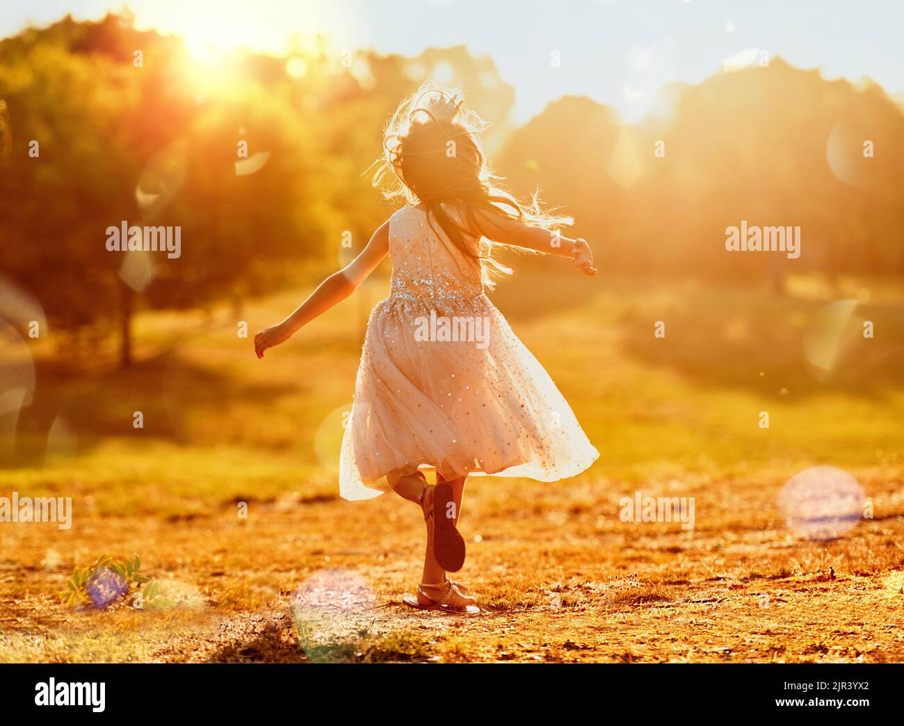 I want to be a kid forever. an adorable little girl playing outdoors. Stock Photo