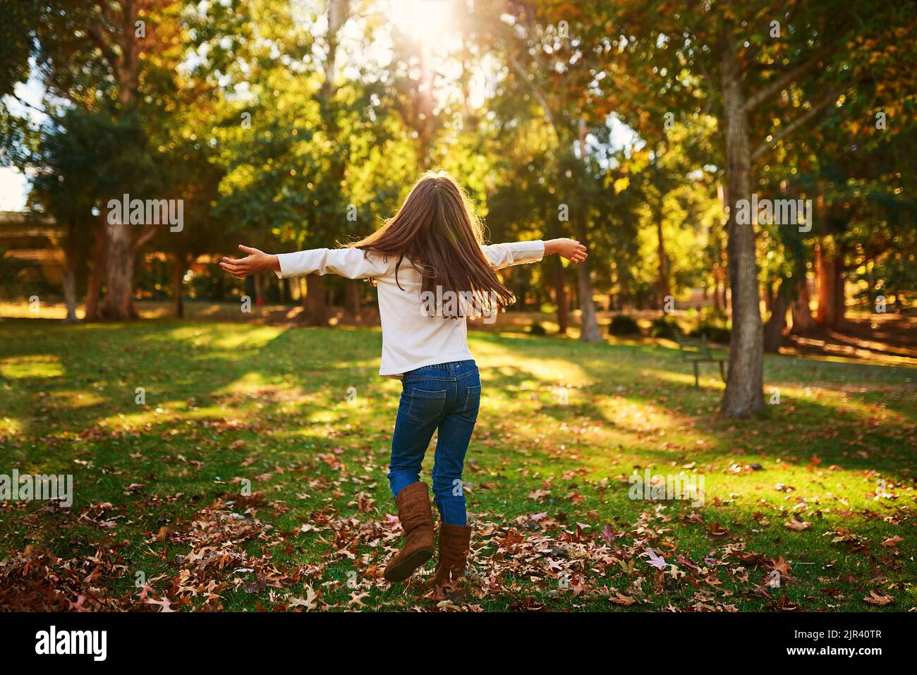 Autumn is awesome. a happy little girl playing in the autumn leaves outdoors. Stock Photo