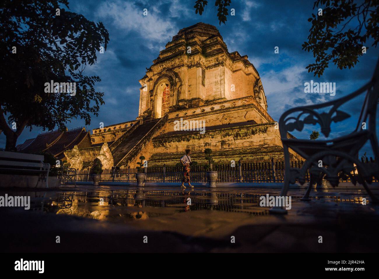 Ancient collapse pagoda in Chedi Luang temple with tourist walking in rainy day. Stock Photo